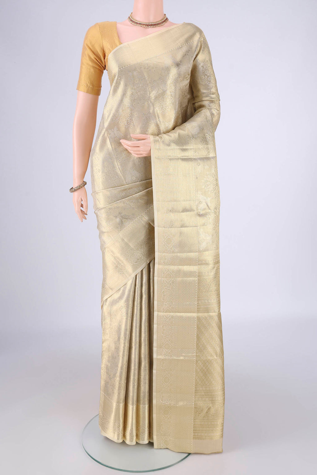 Golden Kanjivaram Silk Saree with Zari Brocade on the body and Zari Border.  displayed on a mannequin