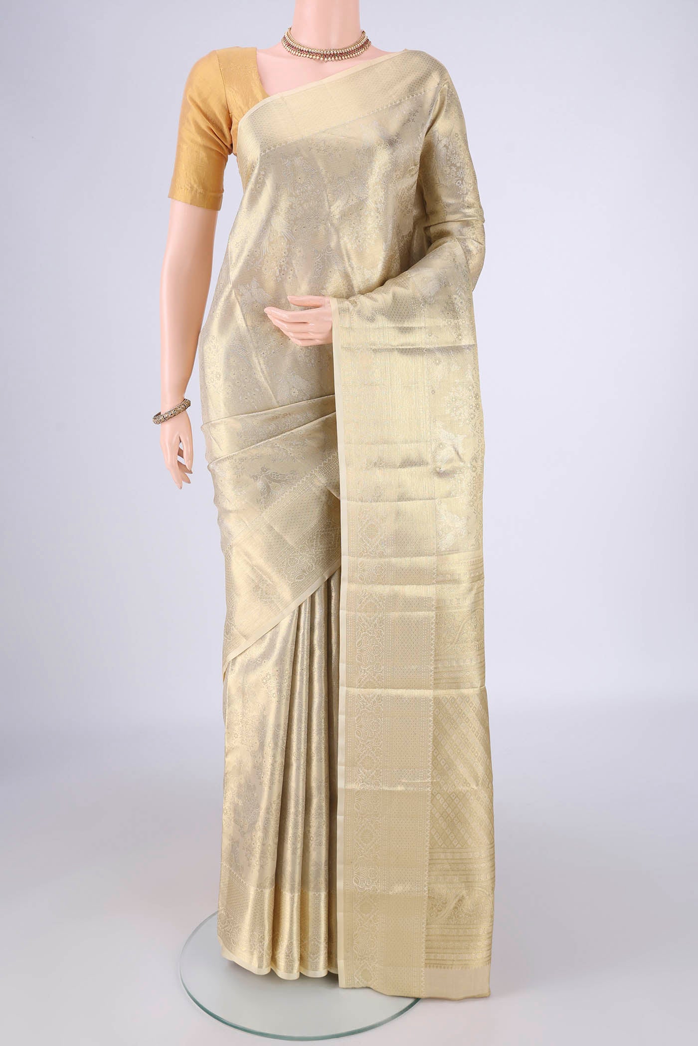 Golden Kanjivaram Silk Saree with Zari Brocade on the body and Zari Border.  displayed on a mannequin
