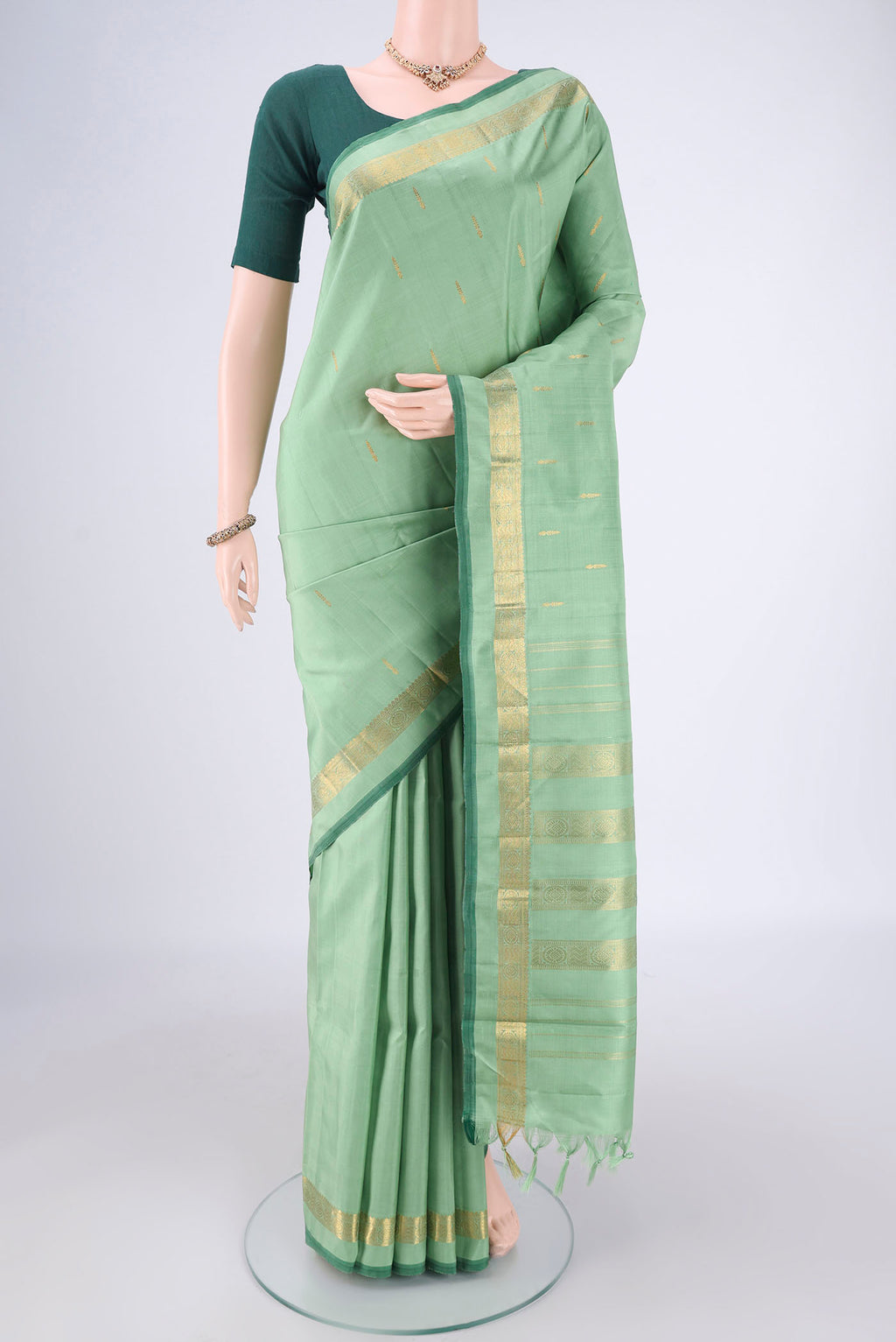 Light Green Kanchipuram Silk Saree with Zari Butta on the body and Zari Border.  displayed on a mannequin