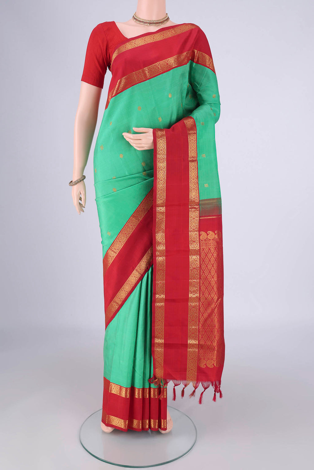 Green Dual Tone Kanjivaram Silk Saree with Zari Butta on the body and Zari Border.  displayed on a mannequin