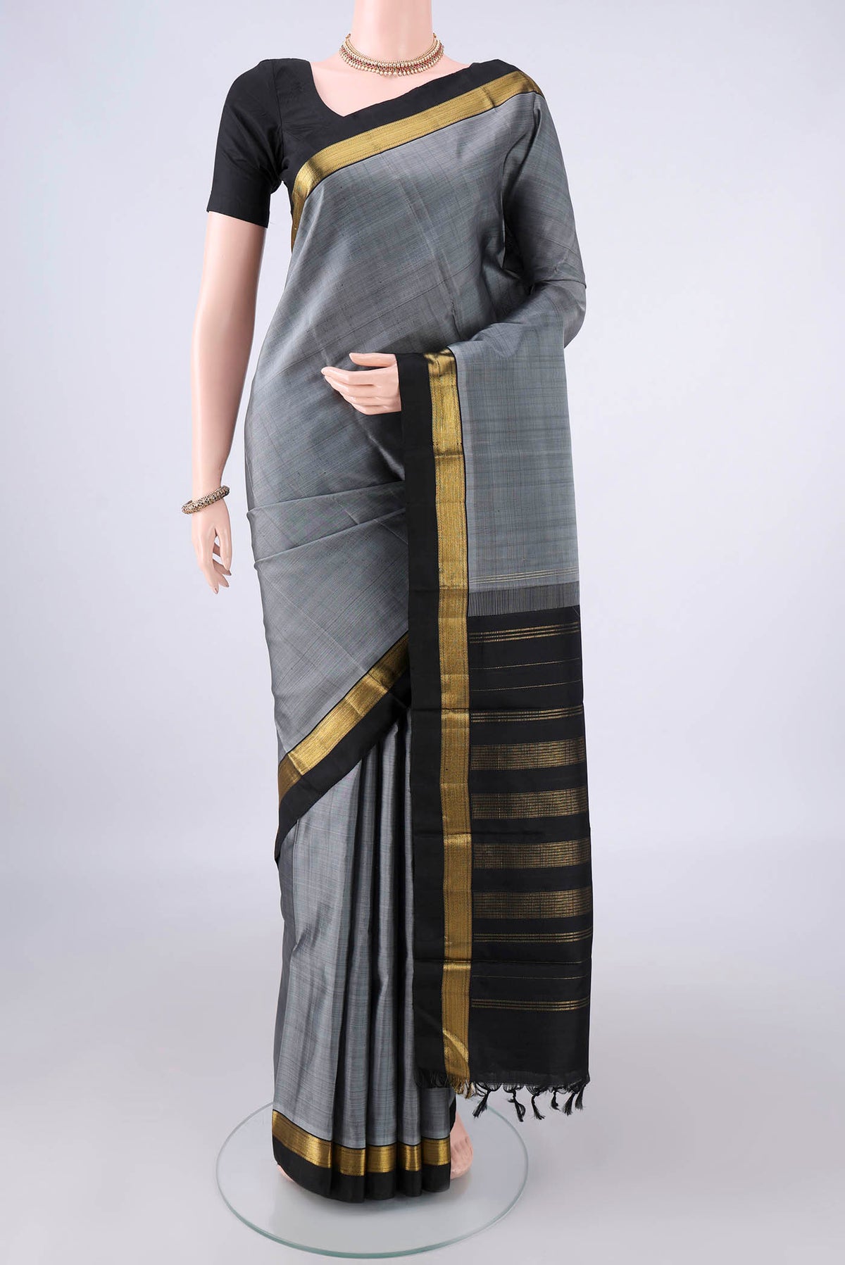 Pure Silk Grey Kanchipuram Saree with Plain Body and Zari Border.  displayed on a mannequin