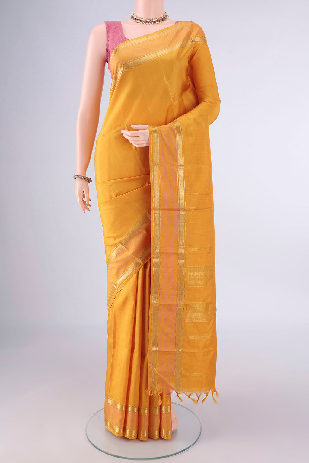 Pure Silk Mustard Kanchipuram Saree with Plain Body and Zari Border.  displayed on a mannequin