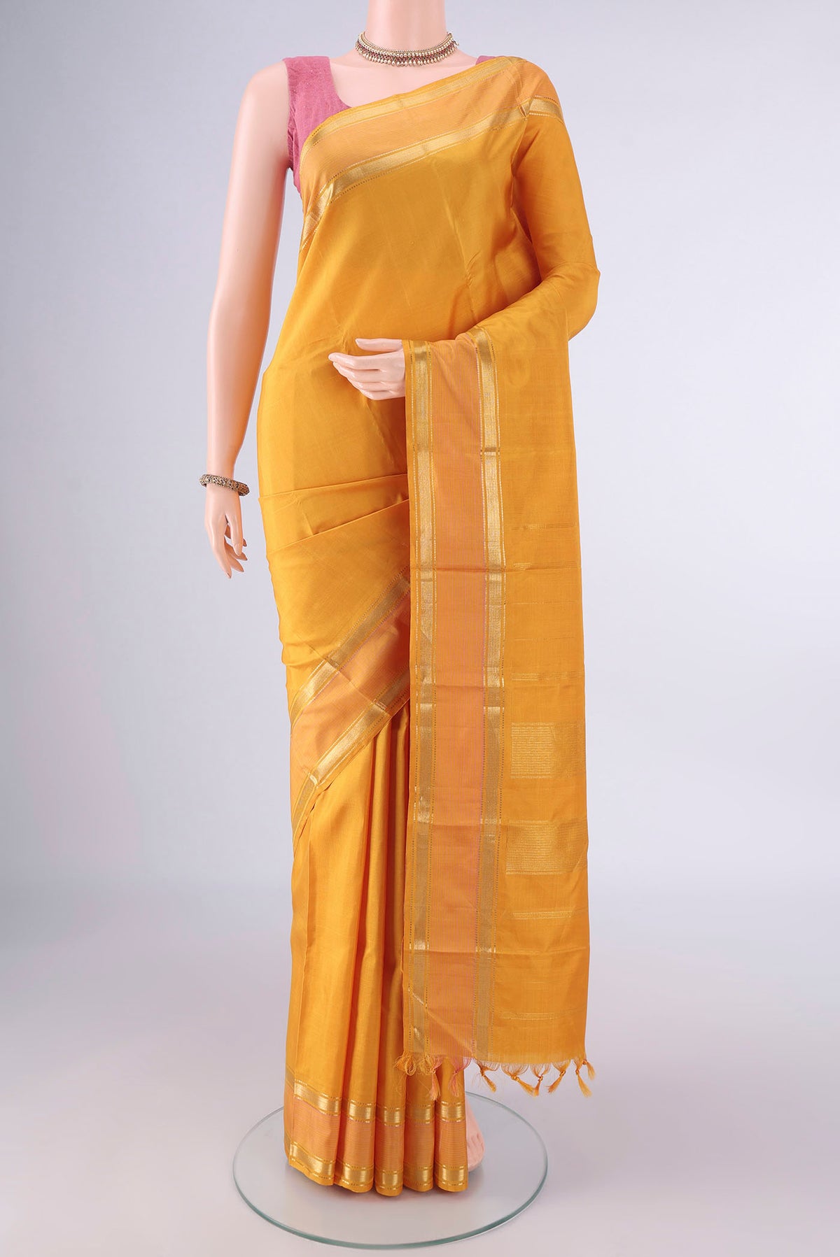 Pure Silk Mustard Kanchipuram Saree with Plain Body and Zari Border.  displayed on a mannequin