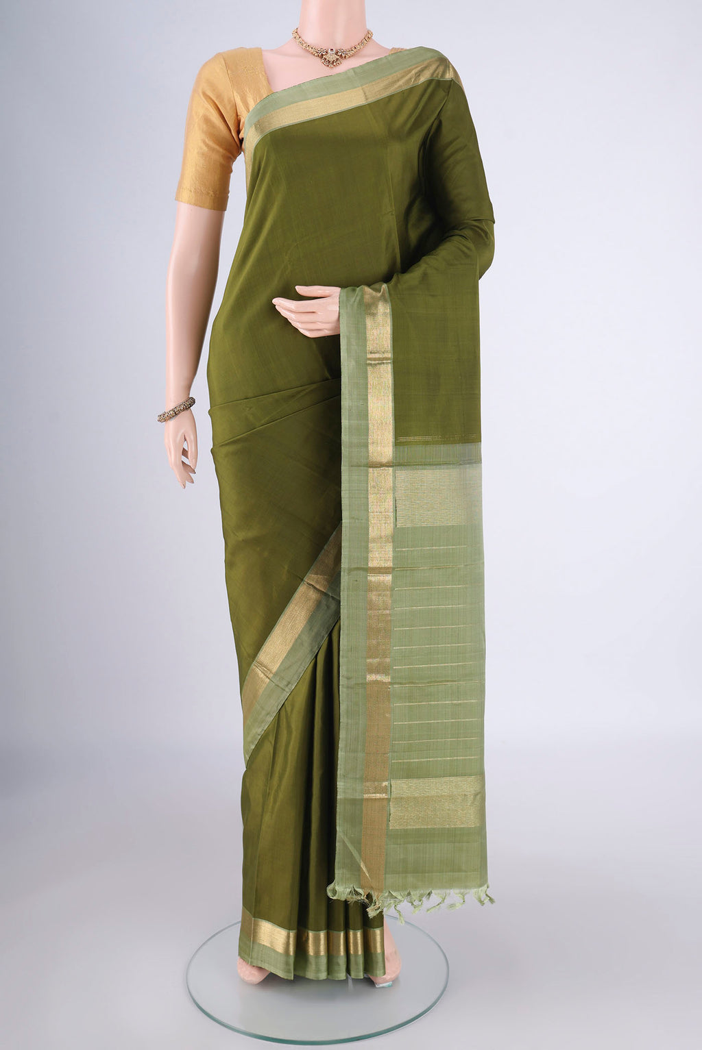 Mehandi Green Kanchipuram Silk Saree with Plain Body and Zari Border.  displayed on a mannequin