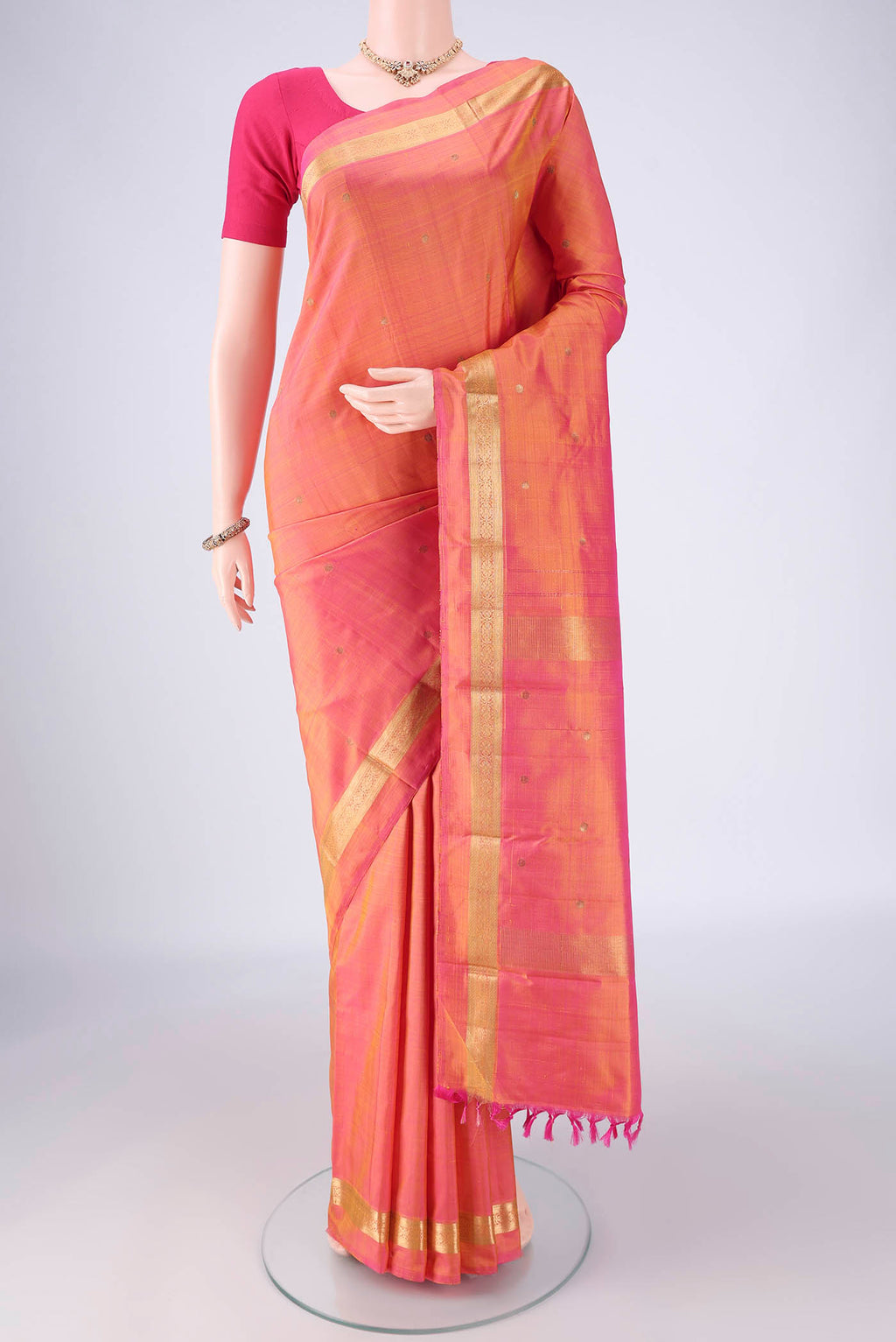 Pinkish Yellow Kanjivaram Silk Saree with Zari Butta on the body and Zari Border.  displayed on a mannequin