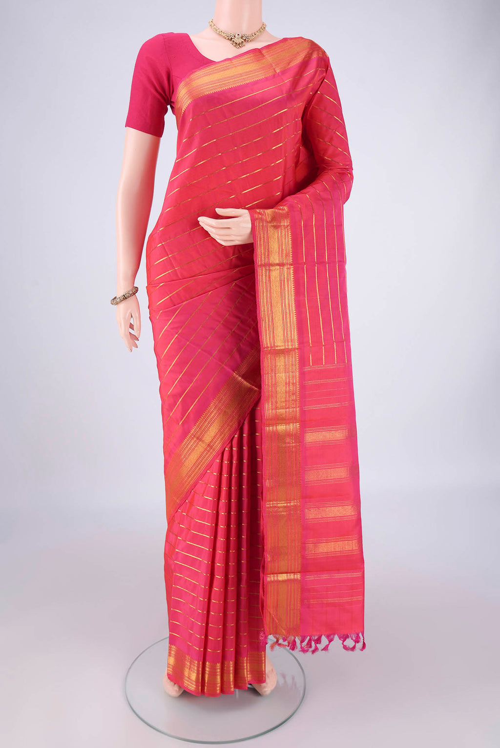 Dark Pink Kanchipuram Silk Saree with Stripes on the body and Thin Zari Line.  displayed on a mannequin