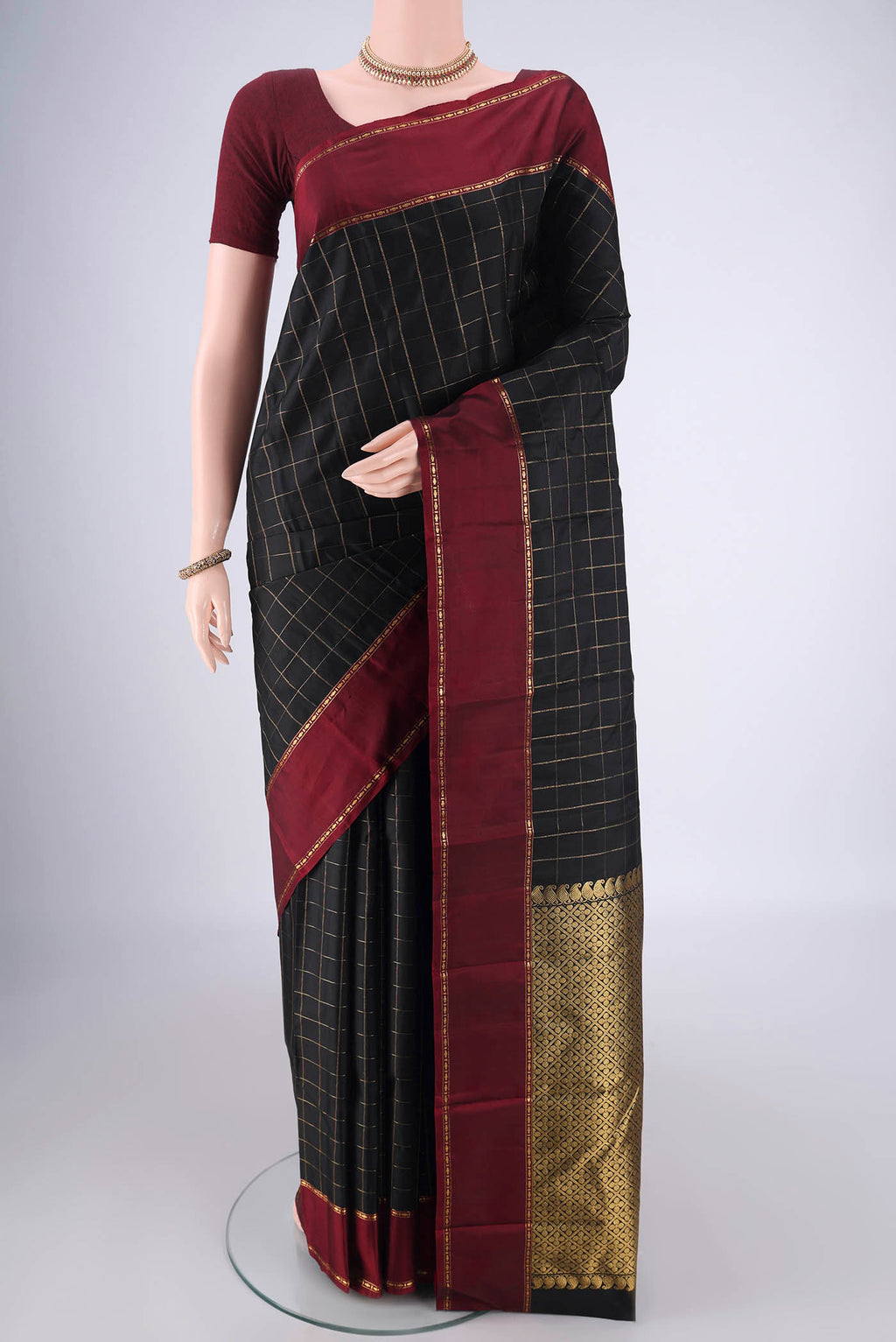Black Kanchipuram Silk Saree with Checked design on the body and Thin Zari Line.  displayed on a mannequin