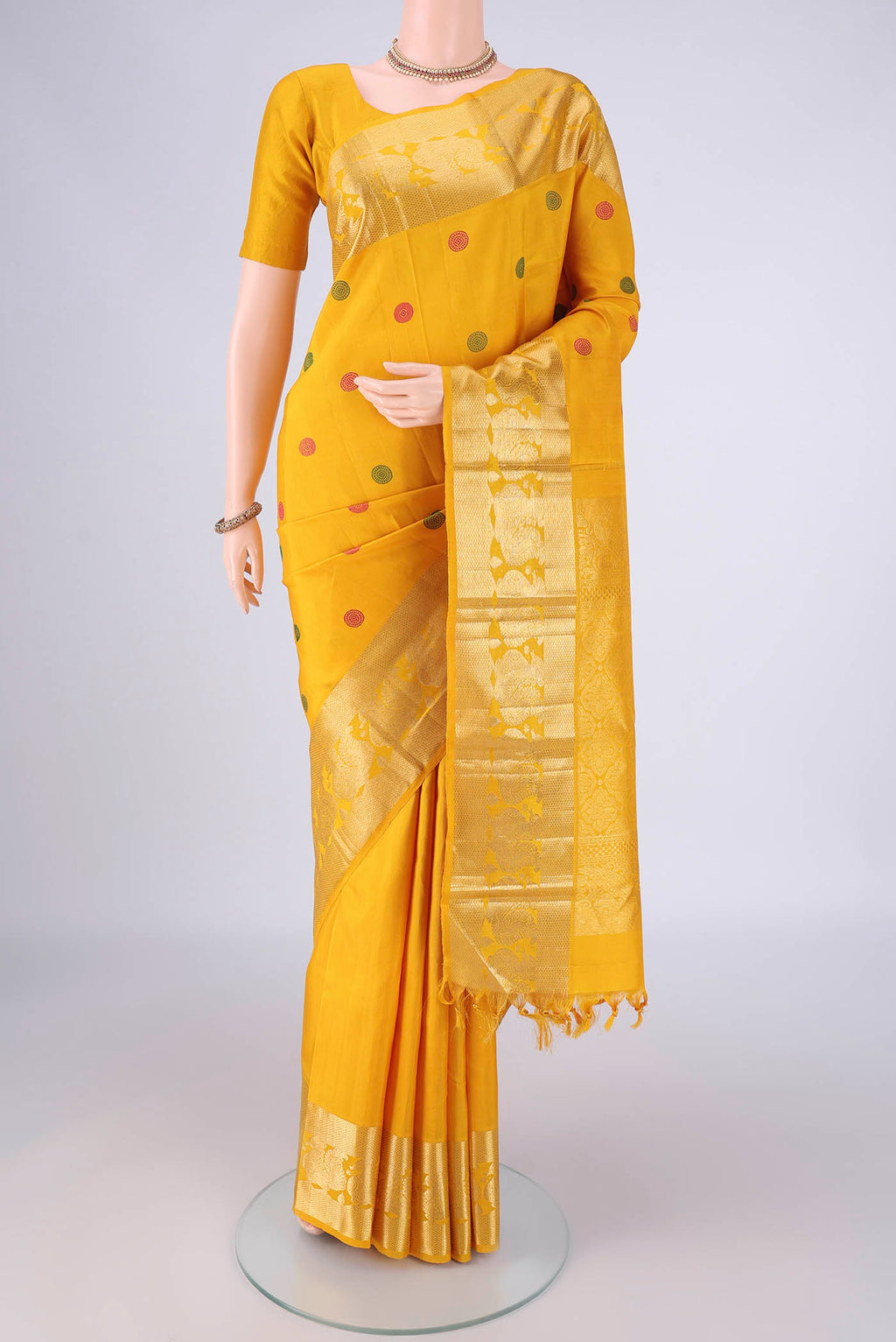 Mustard Dual Tone Kanjivaram Silk Saree with Thread Butta on the body and Zari Border.  displayed on a mannequin
