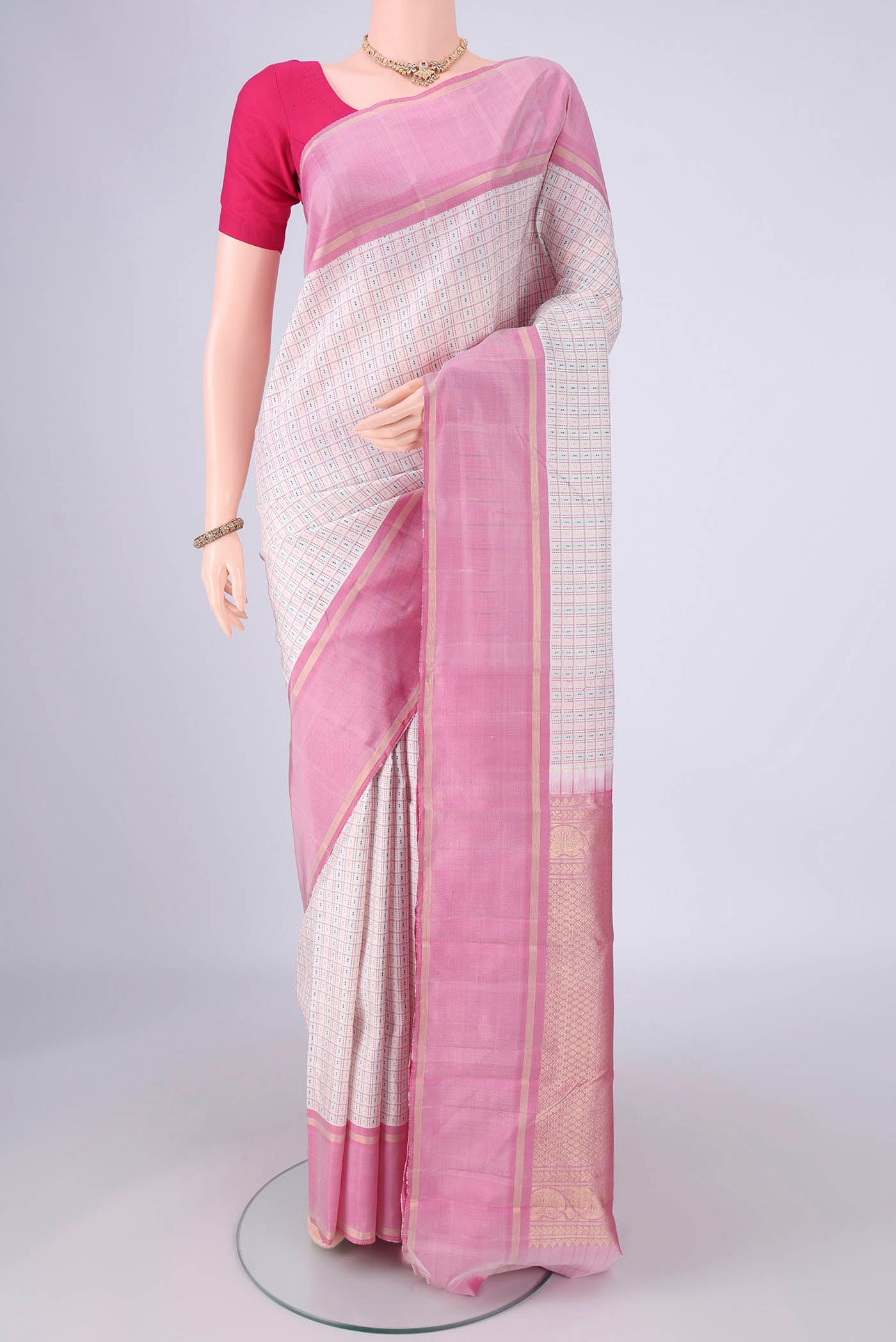 Off White Kanchipuram Silk Saree with Checked design on the body and Zari Border.  displayed on a mannequin