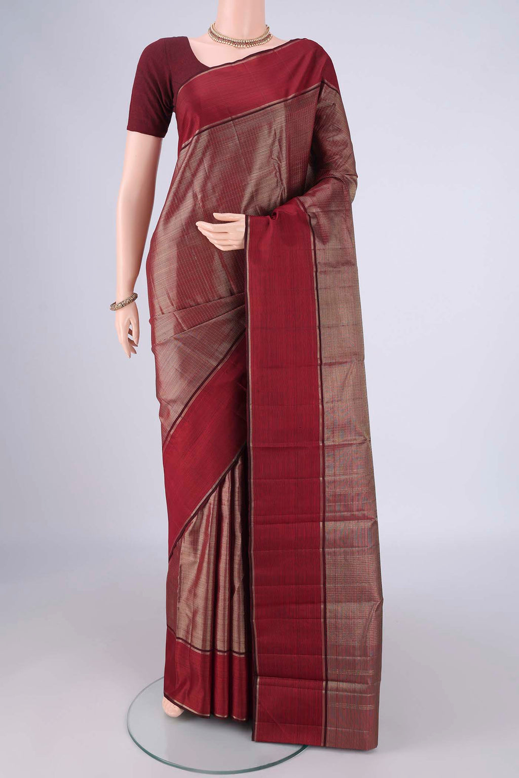 Maroon Kanjivaram Silk Saree with Zari Brocade on the body and Zari Border.  displayed on a mannequin