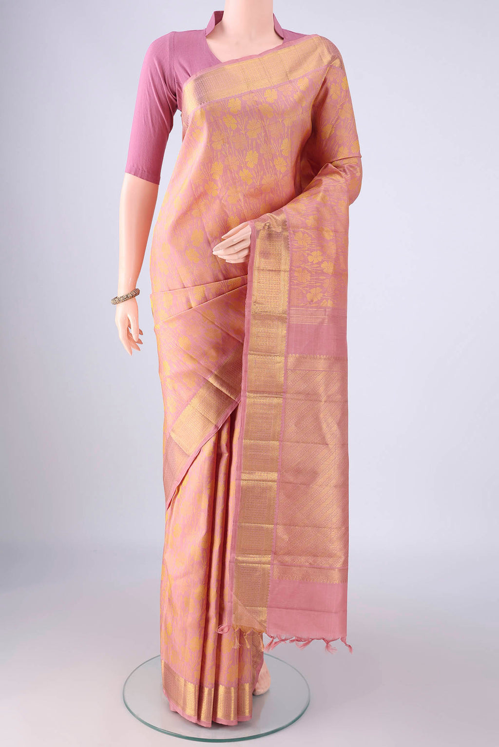 Rose pink Kanjivaram Silk Saree with Jacquard design on the body and Zari Border.  displayed on a mannequin
