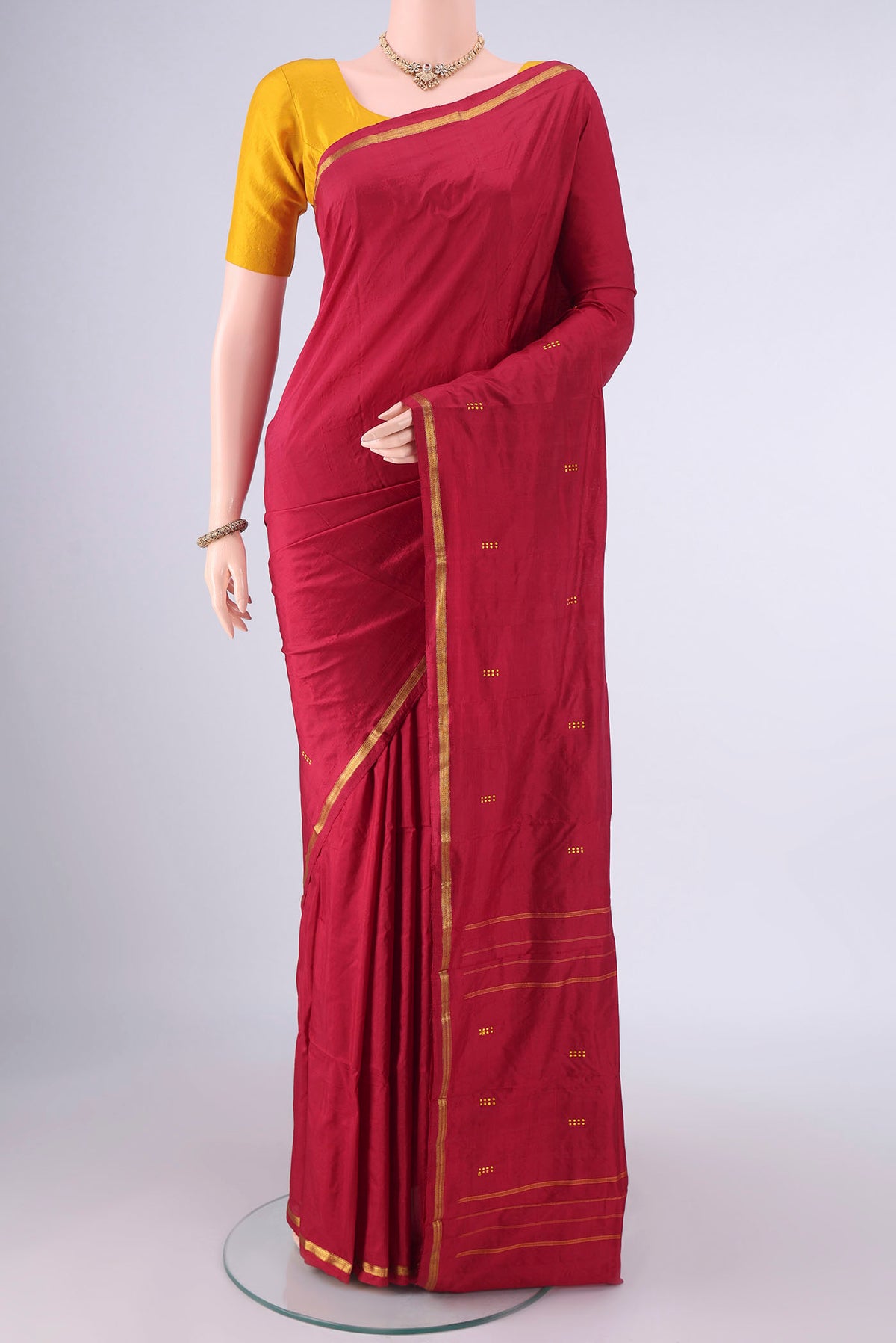 Pure Silk Deep Red Kanchipuram Saree with Thread Butta on the body and Zari Border.  displayed on a mannequin