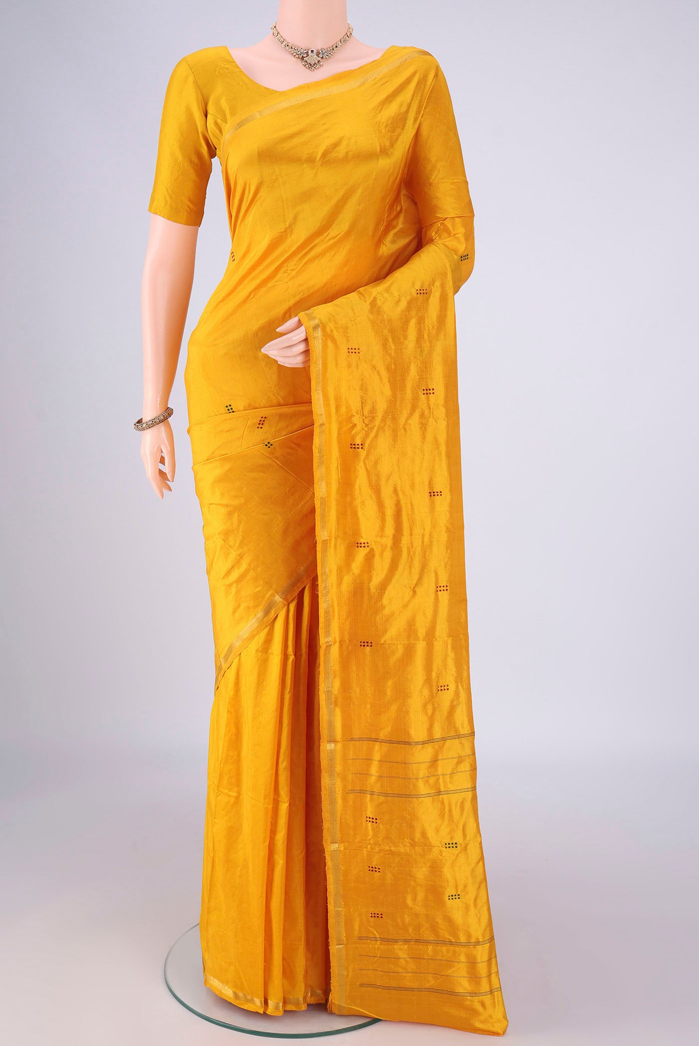 Yellow Kanchipuram Silk Saree with Thread Butta on the body and Zari Border.  displayed on a mannequin