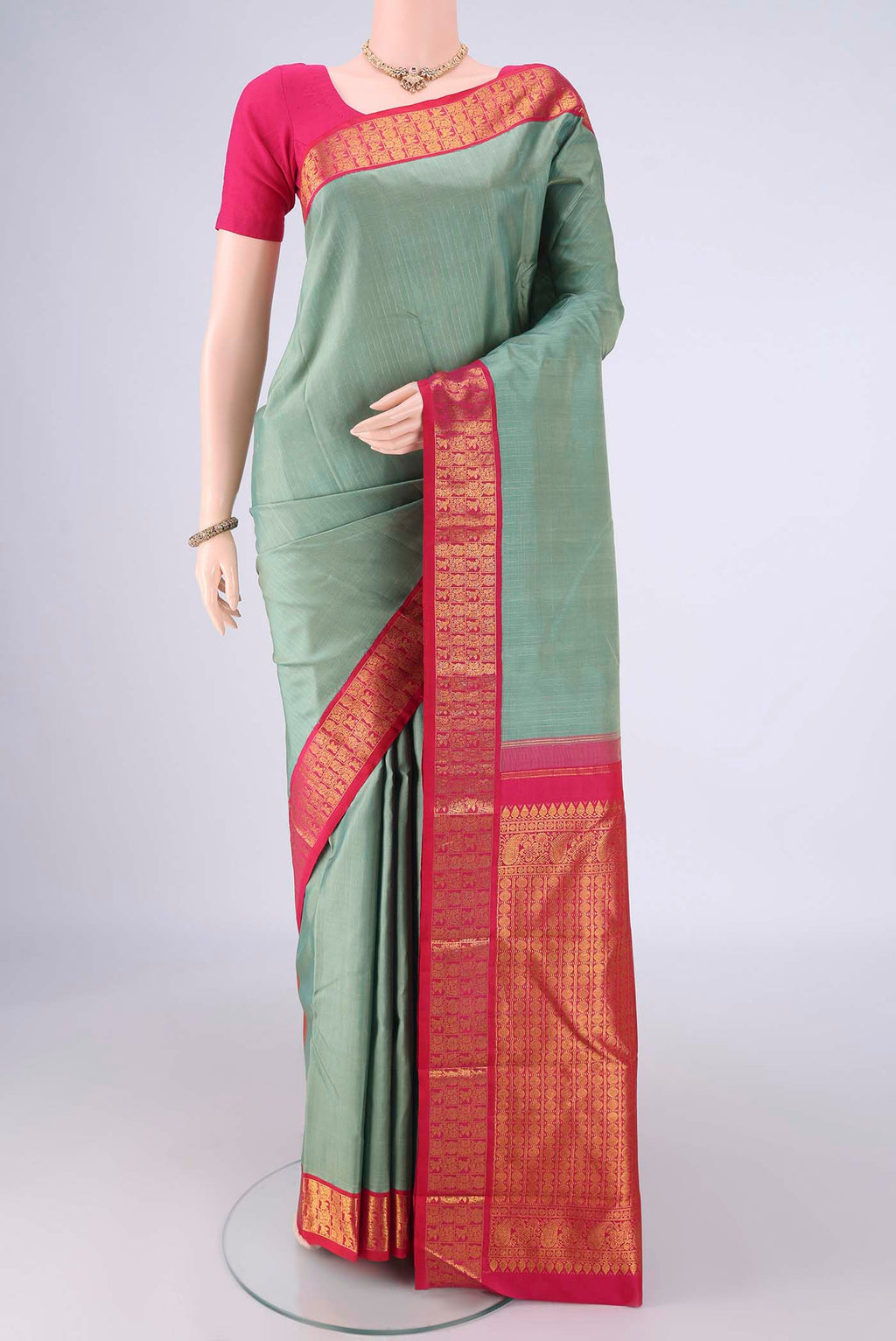 Pista Green Kanjivaram Silk Saree with Checked design on the body and Zari Border.  displayed on a mannequin