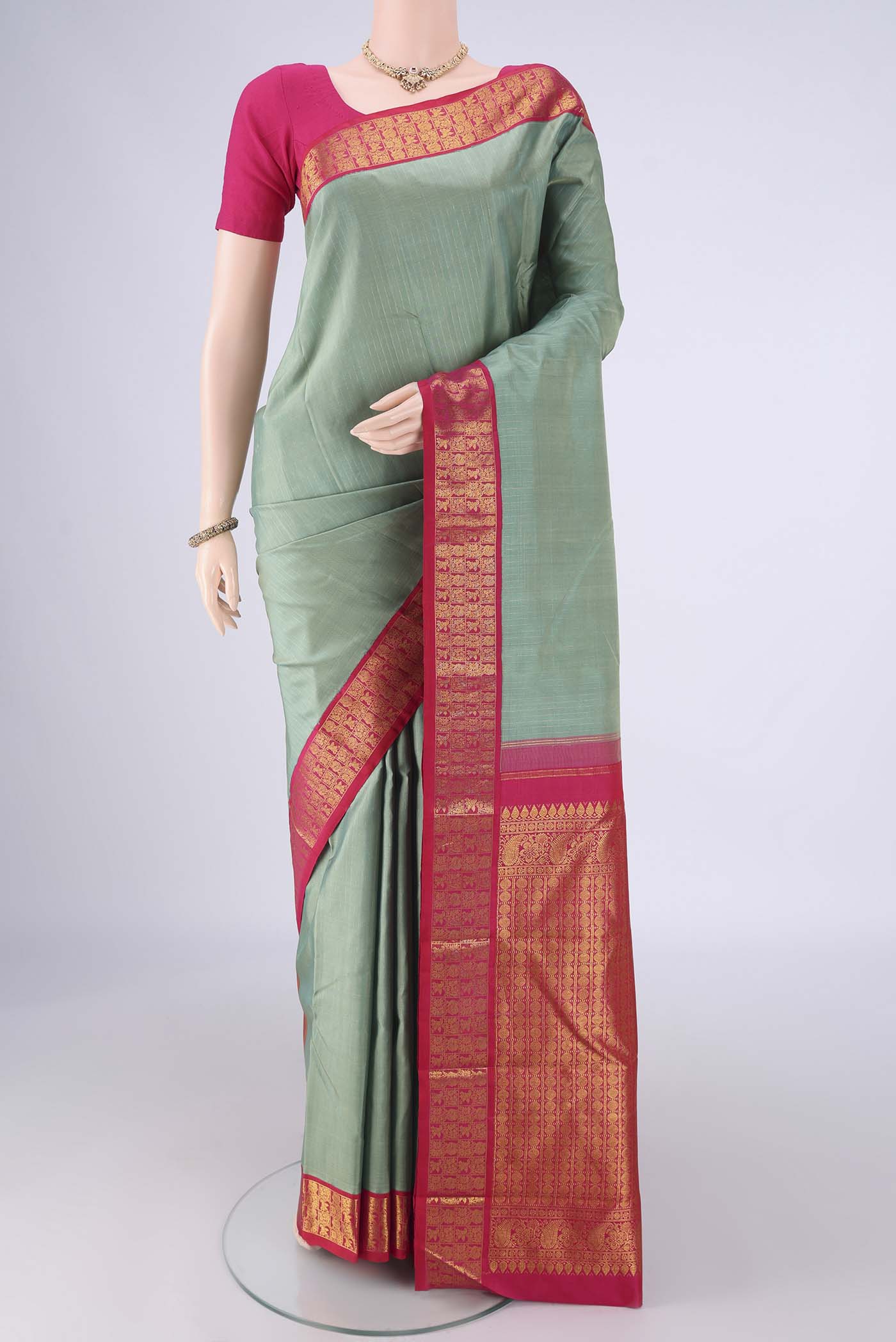 Pista Green Kanjivaram Silk Saree with Checked design on the body and Zari Border.  displayed on a mannequin