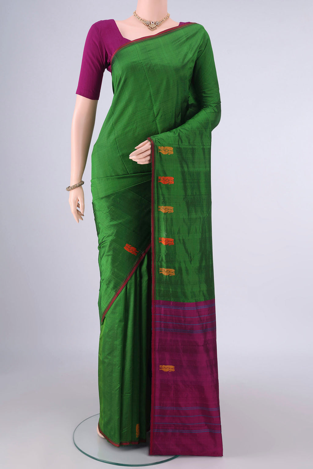 Pure Silk Green Kanchipuram Saree with Plain Body and Zari And Thread Border.  displayed on a mannequin