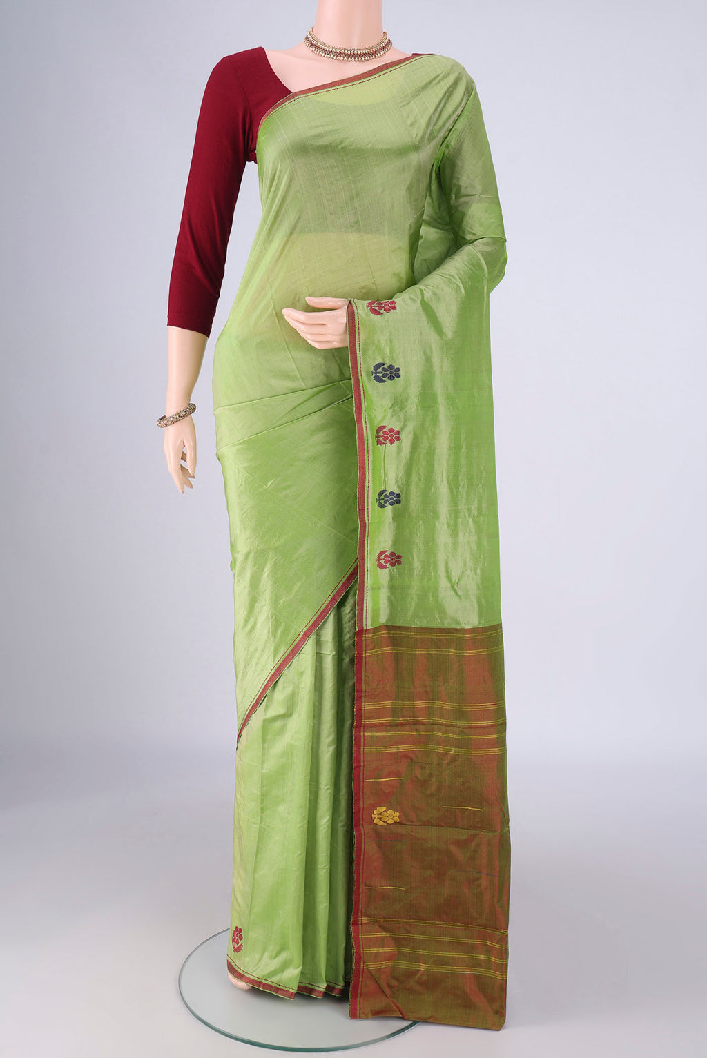 Green Kanchipuram Silk Saree with Plain Body and Thread Border.  displayed on a mannequin
