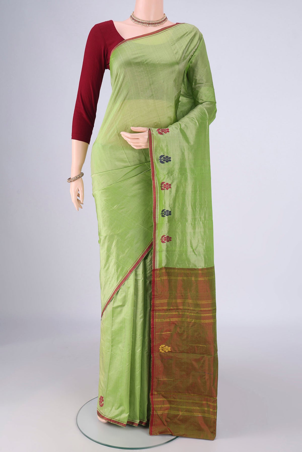 Green Kanchipuram Silk Saree with Plain Body and Thread Border.  displayed on a mannequin