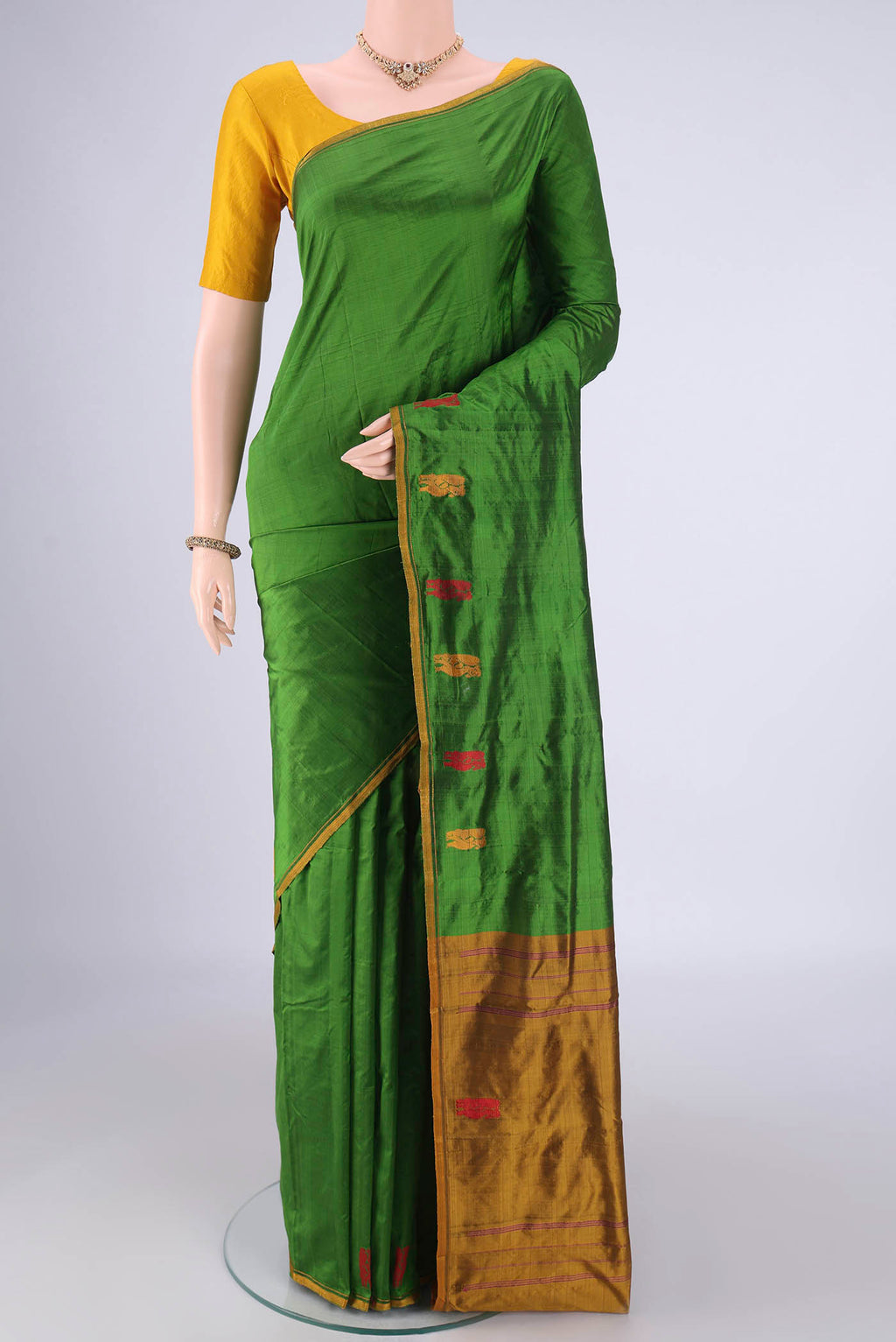Green Kanchipuram Silk Saree with Plain Body and Thread Border.  displayed on a mannequin