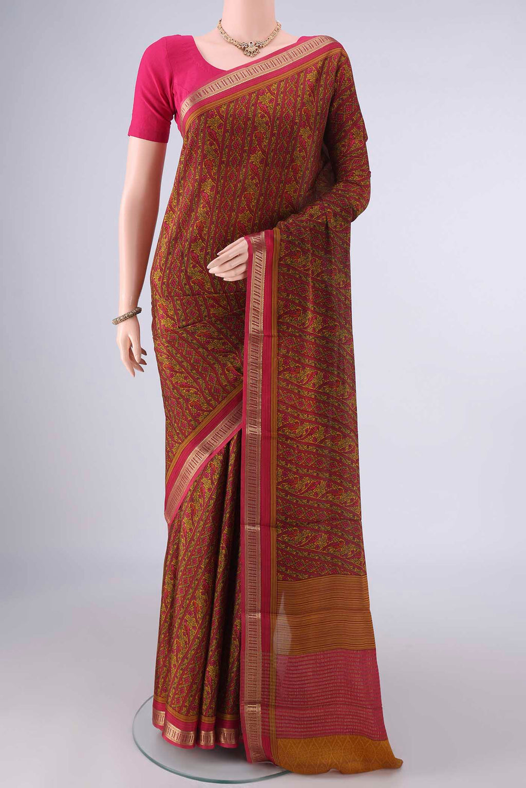 Mustard Mysore Crepe Saree with Printed design on the body and Zari Border.  displayed on a mannequin