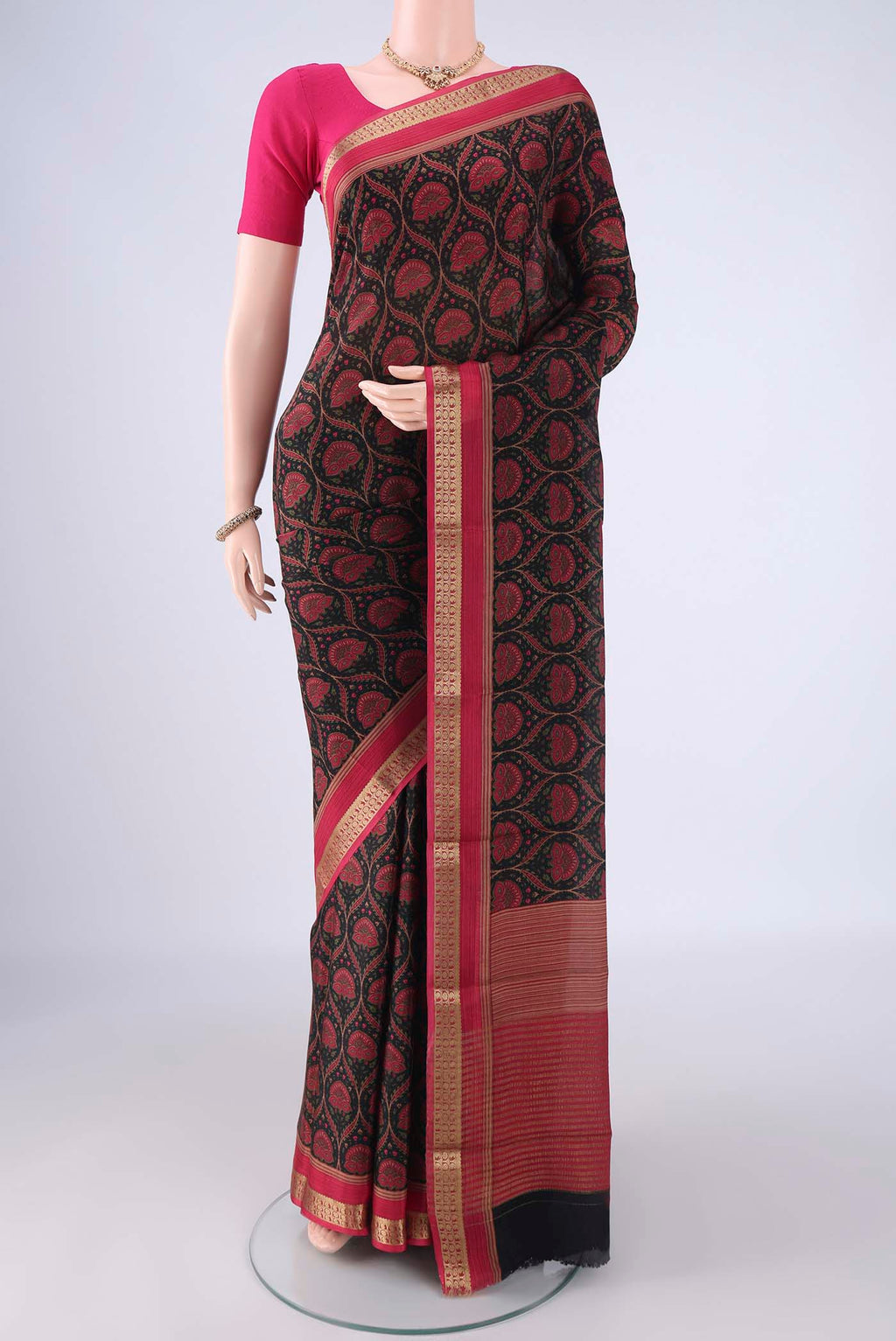 Black Crepe Saree with Floral Print on the body and Zari Border.  displayed on a mannequin