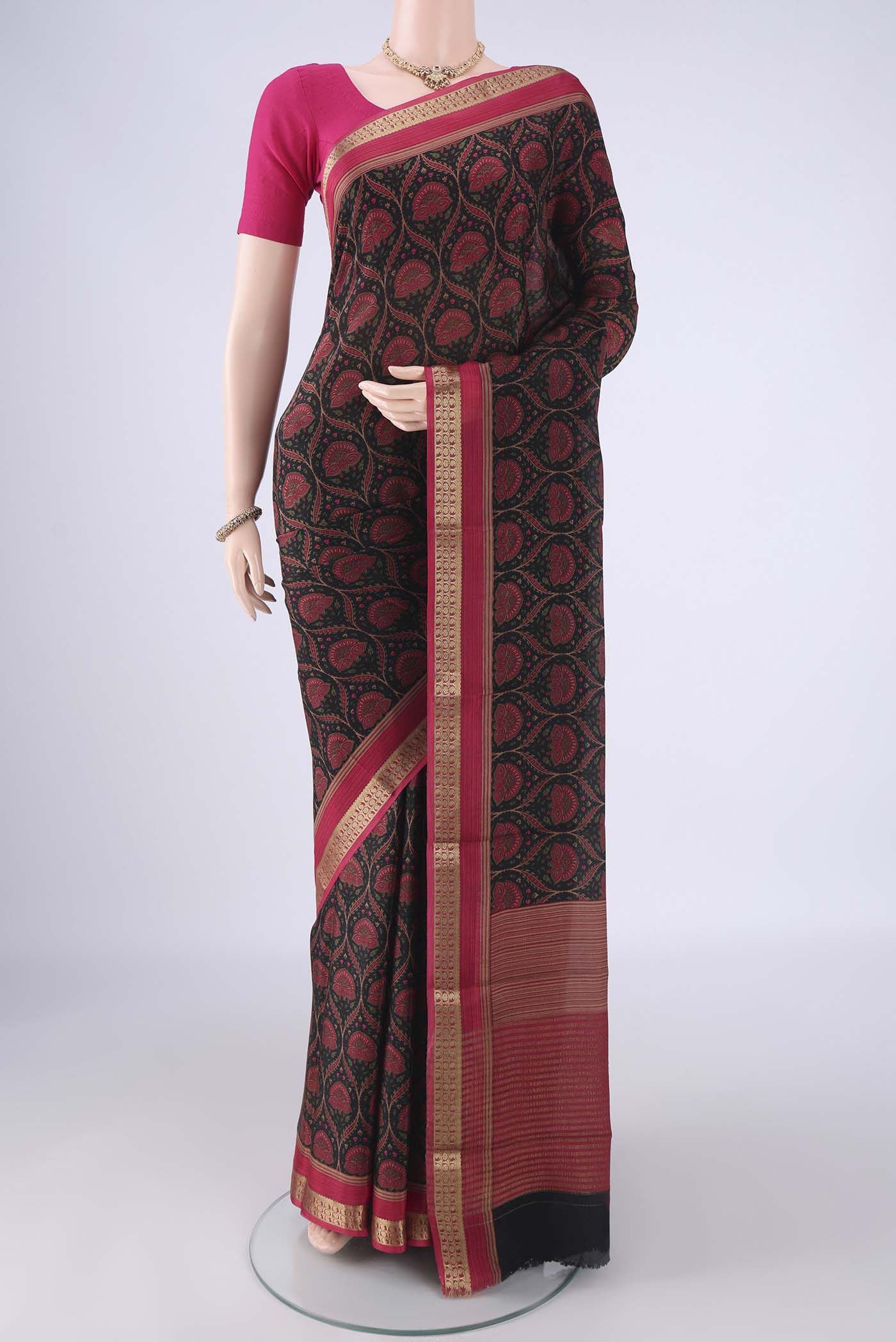 Black Crepe Saree with Floral Print on the body and Zari Border.  displayed on a mannequin