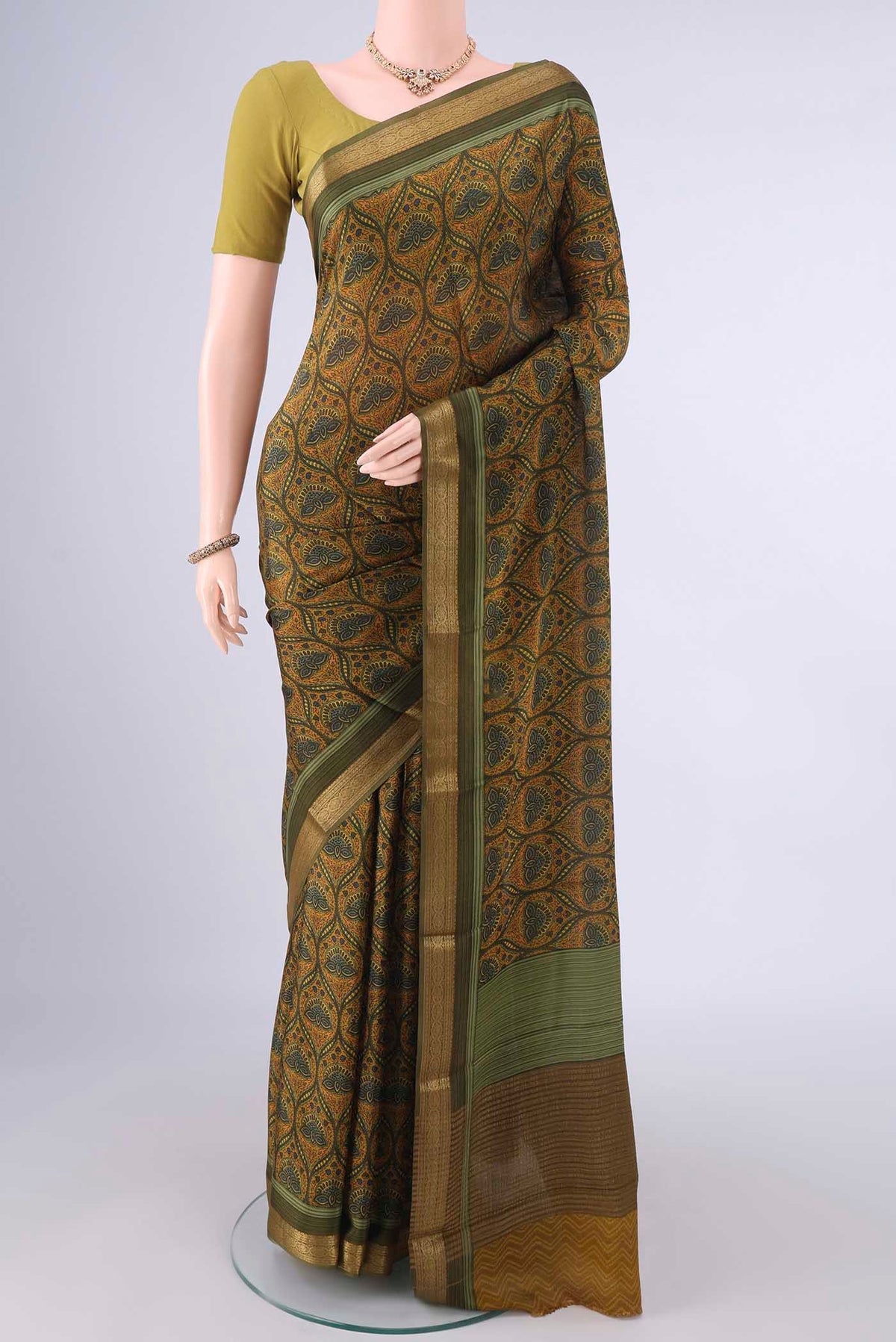 Mehandi Green Mysore Crepe Saree with Printed design on the body and Zari Border.  displayed on a mannequin