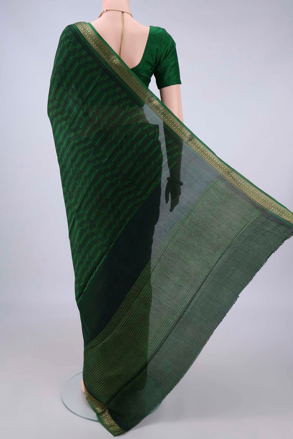 Flat view of Bottle Green Mysore Crepe Saree with Printed design on the body and Zari Border. 