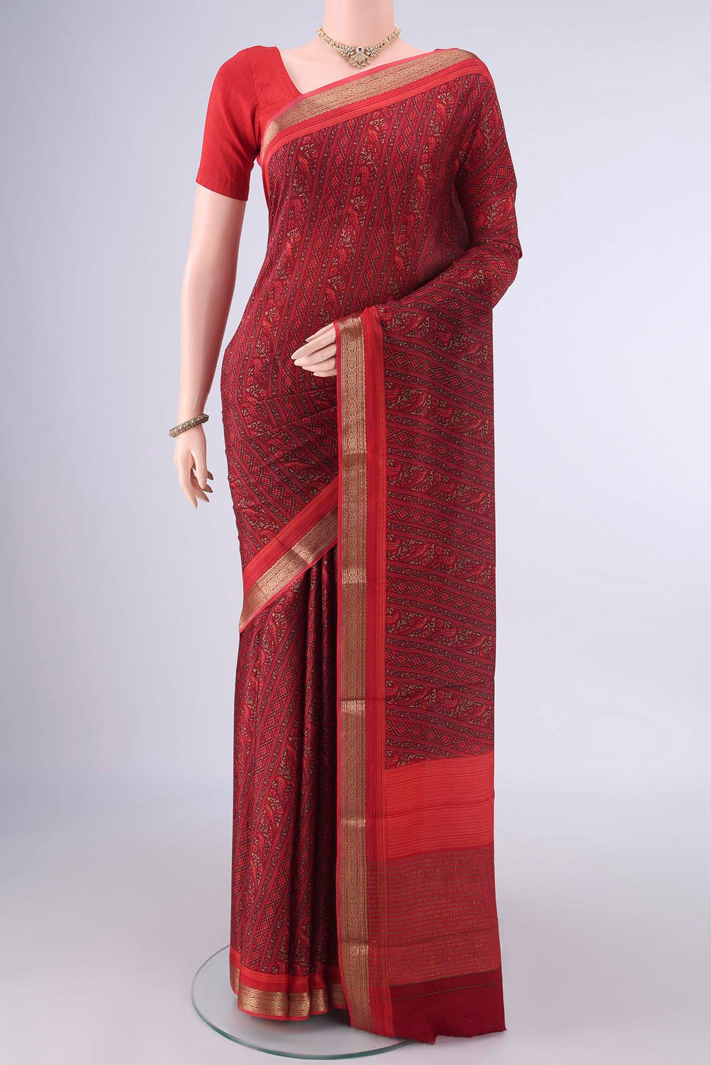 Maroon Mysore Crepe Saree with Printed design on the body and Zari Border.  displayed on a mannequin