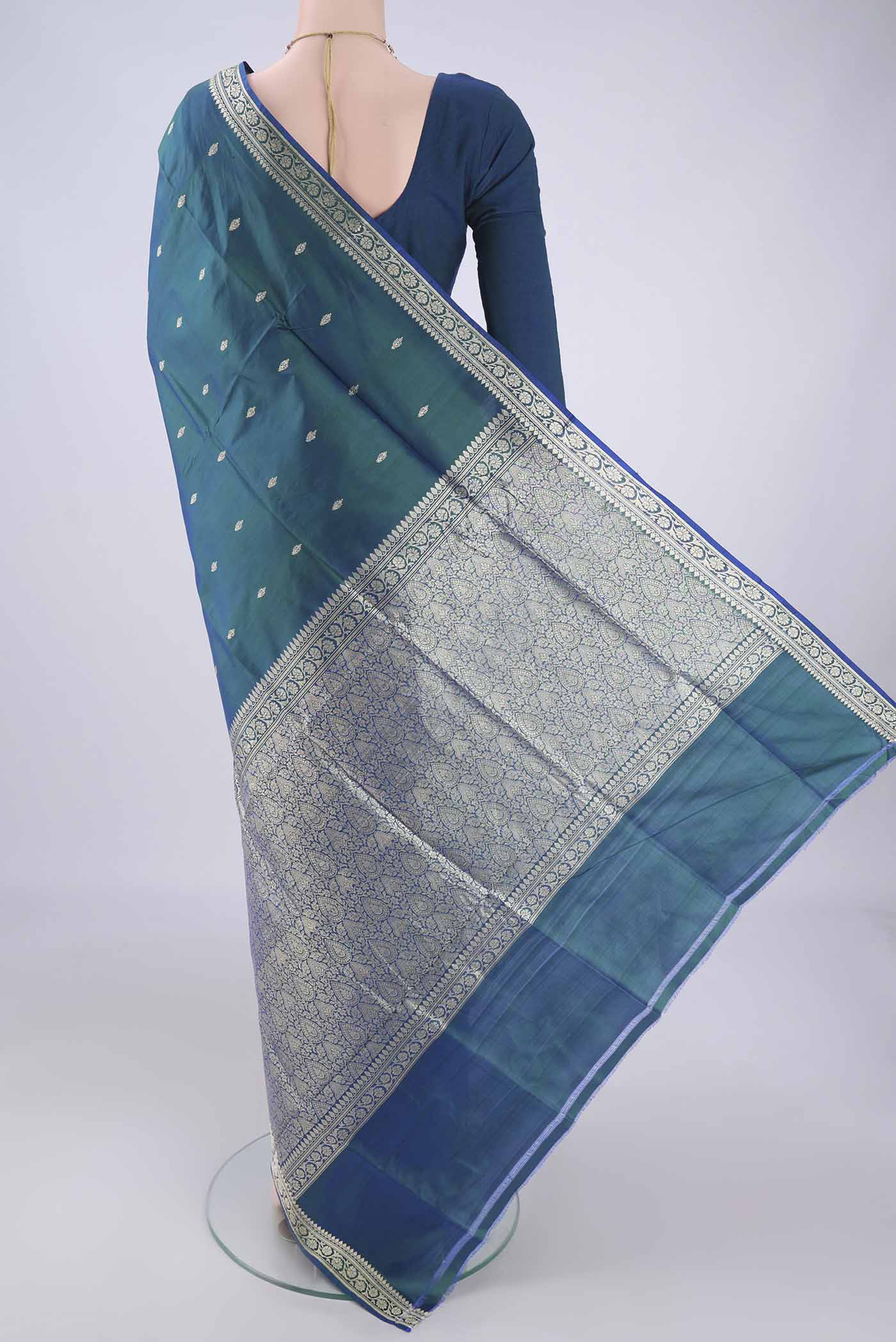 Flat view of Peacock Blue Banarasi Silk Saree with Thread Butta on the body and Thread Border. 