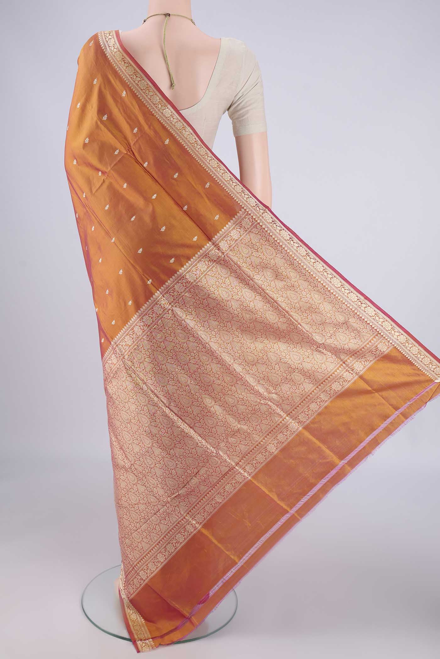 Flat view of Rust Banarasi Silk Saree with Thread Butta on the body and Thread Border. 