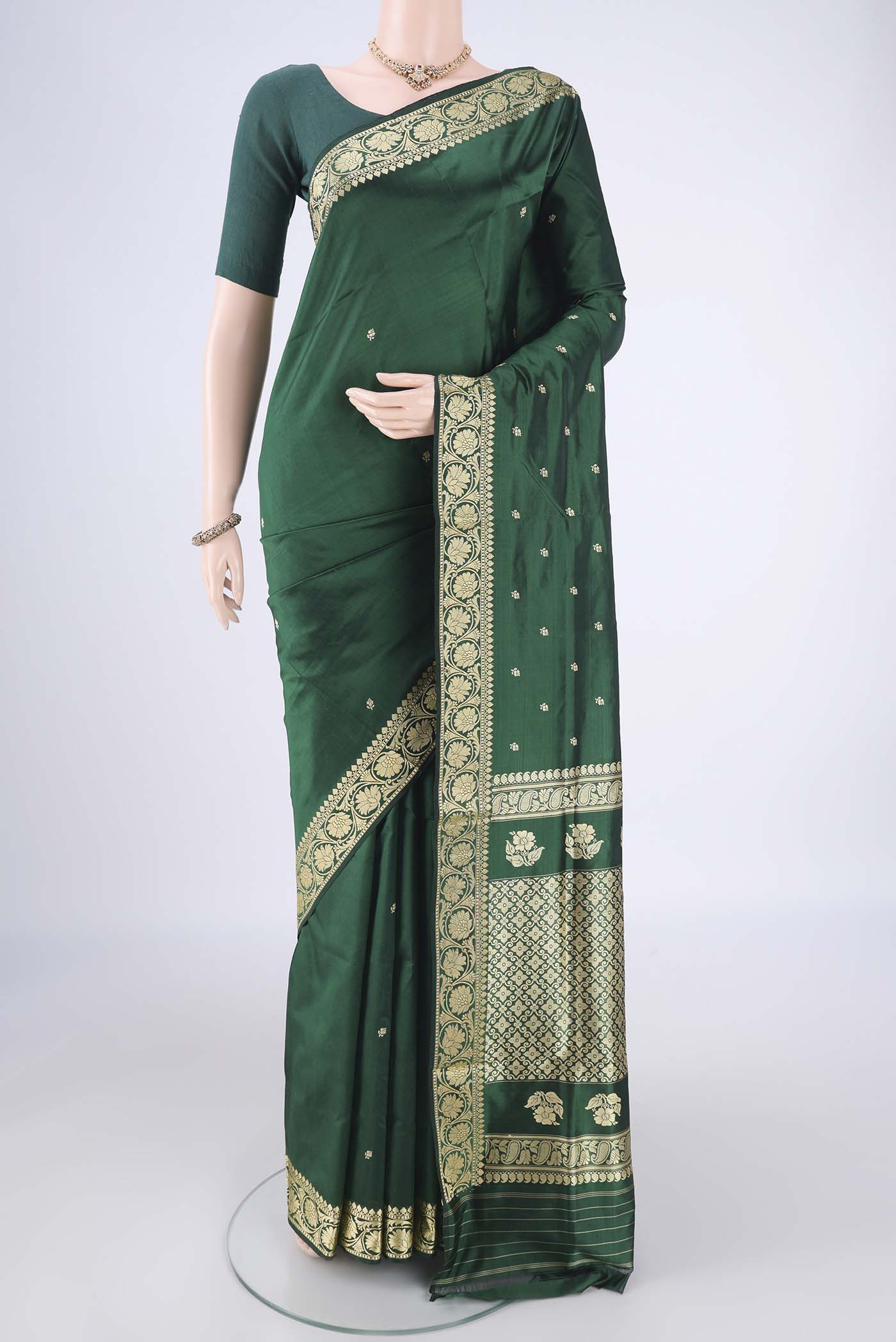 Bottle Green Banarasi Katan Silk Saree with Thread Butta on the body and Thread Border.  displayed on a mannequin