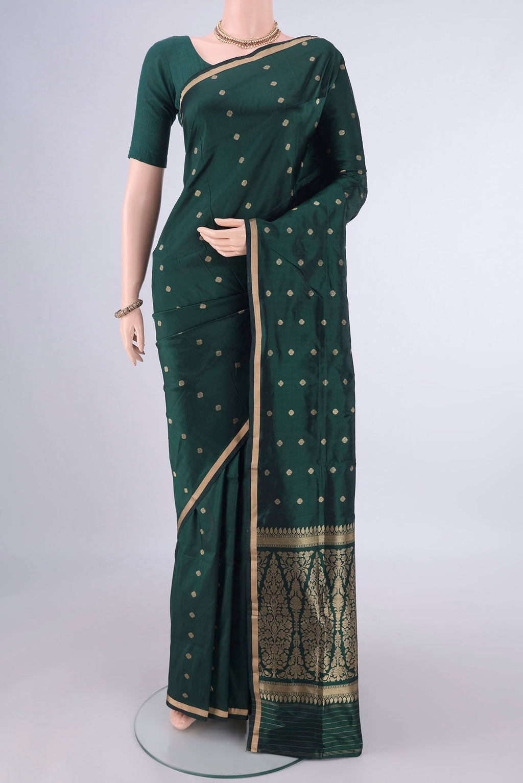 Bottle Green Banarasi Katan Silk Saree with Zari Butta on the body and Zari Border.  displayed on a mannequin