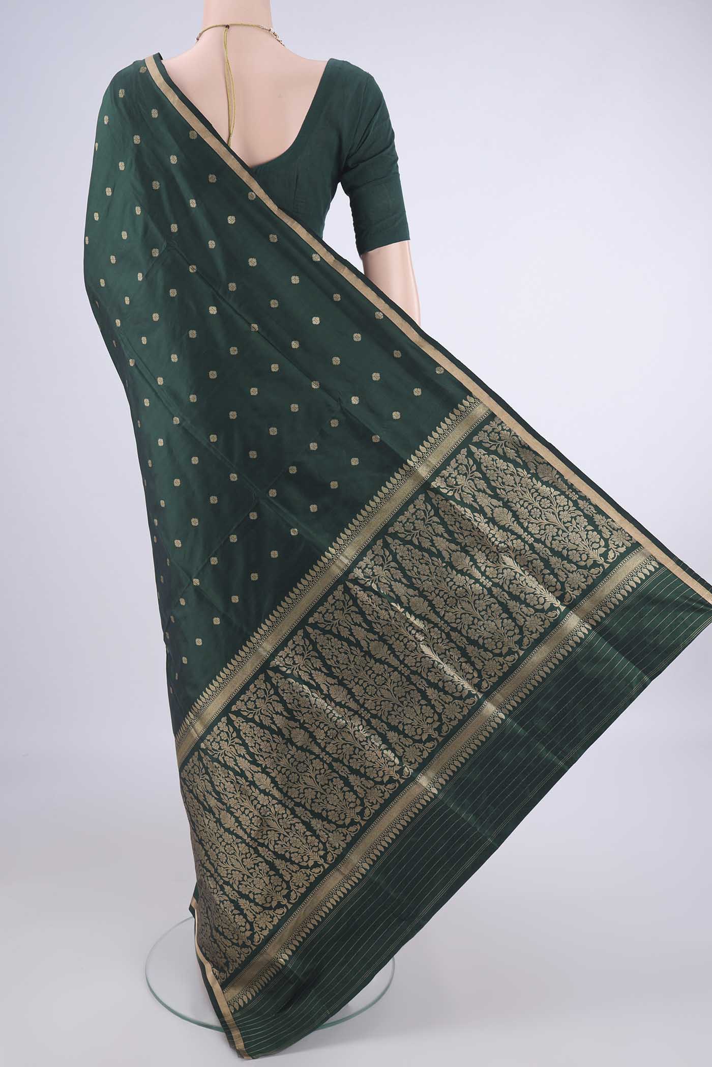 Flat view of Bottle Green Banarasi Katan Silk Saree with Zari Butta on the body and Zari Border. 