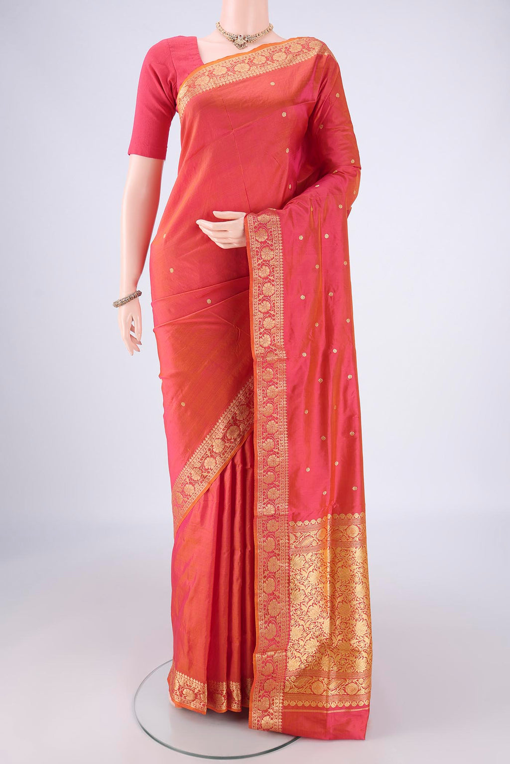 Brick Orange Banarasi Katan Silk Saree with Thread Butta on the body and Thread Border.  displayed on a mannequin