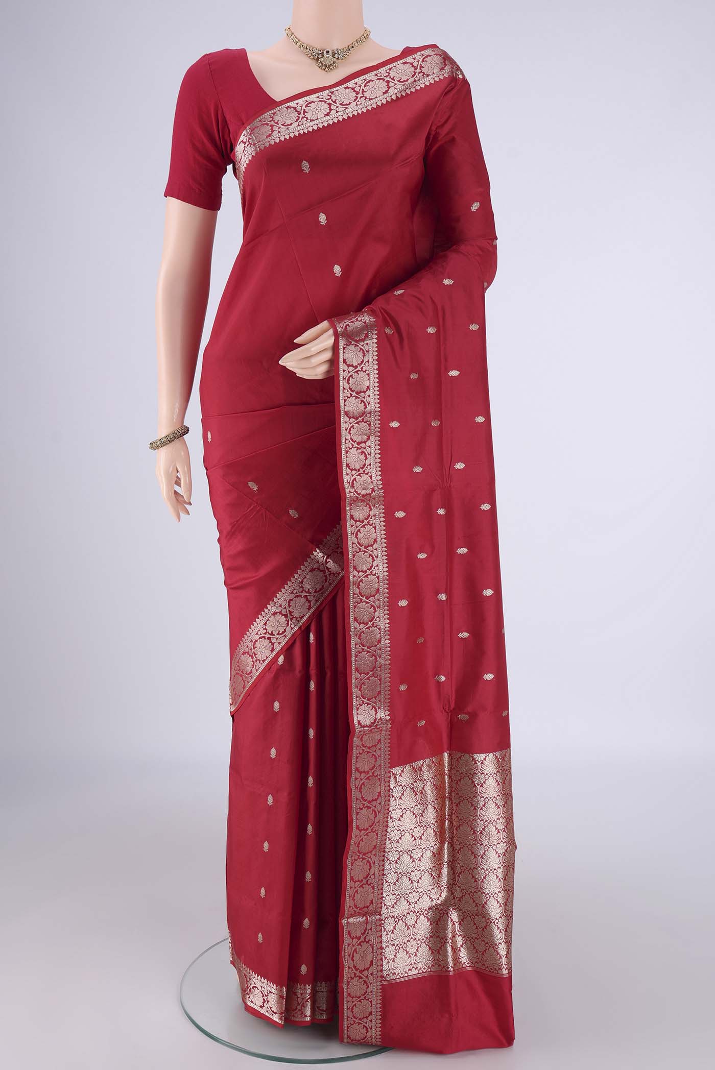 Maroon Banarasi Katan Silk Saree with Zari Butta on the body and Zari Border.  displayed on a mannequin