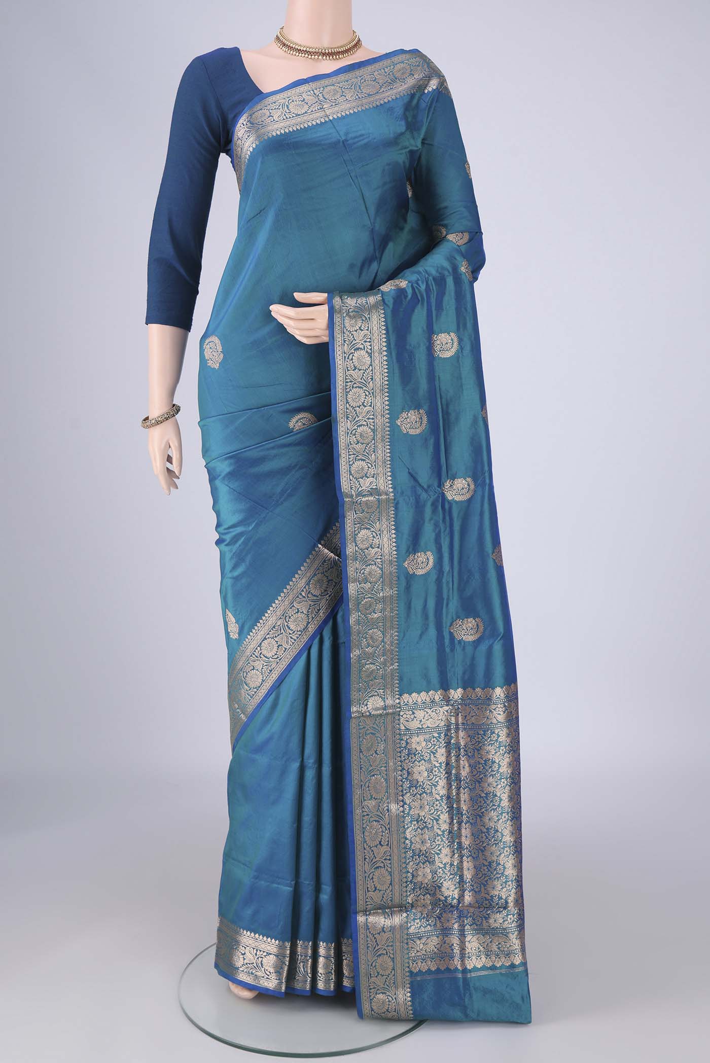 Peacock Blue Dual Tone Banarasi Katan Silk Saree with Zari Butta on the body and Zari Border.  displayed on a mannequin
