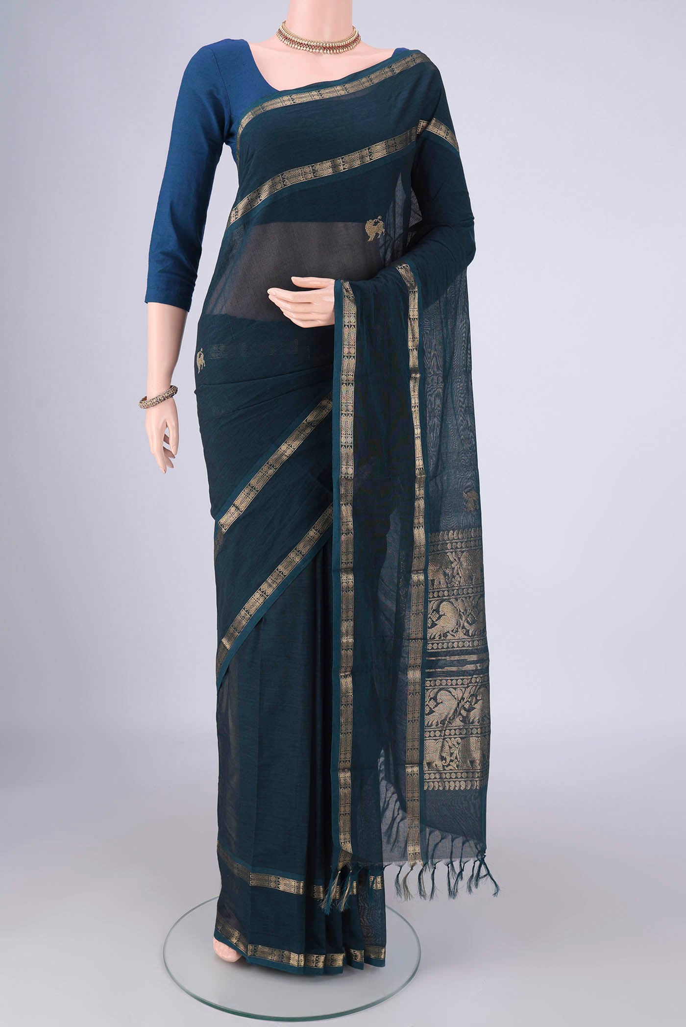 Teal Kanchi Cotton Saree with Zari Butta on the body and Zari Border.  displayed on a mannequin