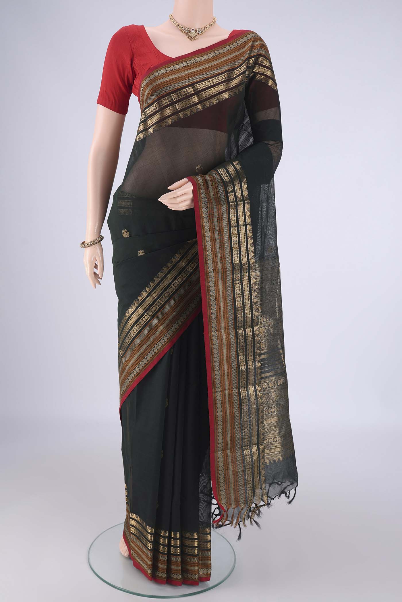 Bottle Green Kanchi Cotton Saree with Zari Butta on the body and Zari Border.  displayed on a mannequin