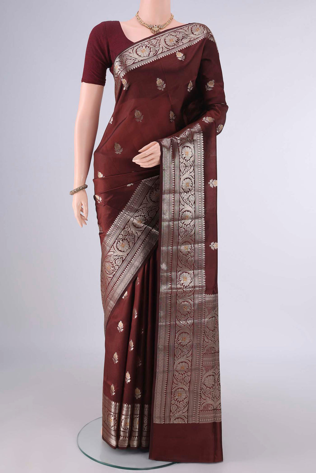 Pure Silk Brown Banarasi Raw Saree with Zari Butta on the body and Zari Border.  displayed on a mannequin