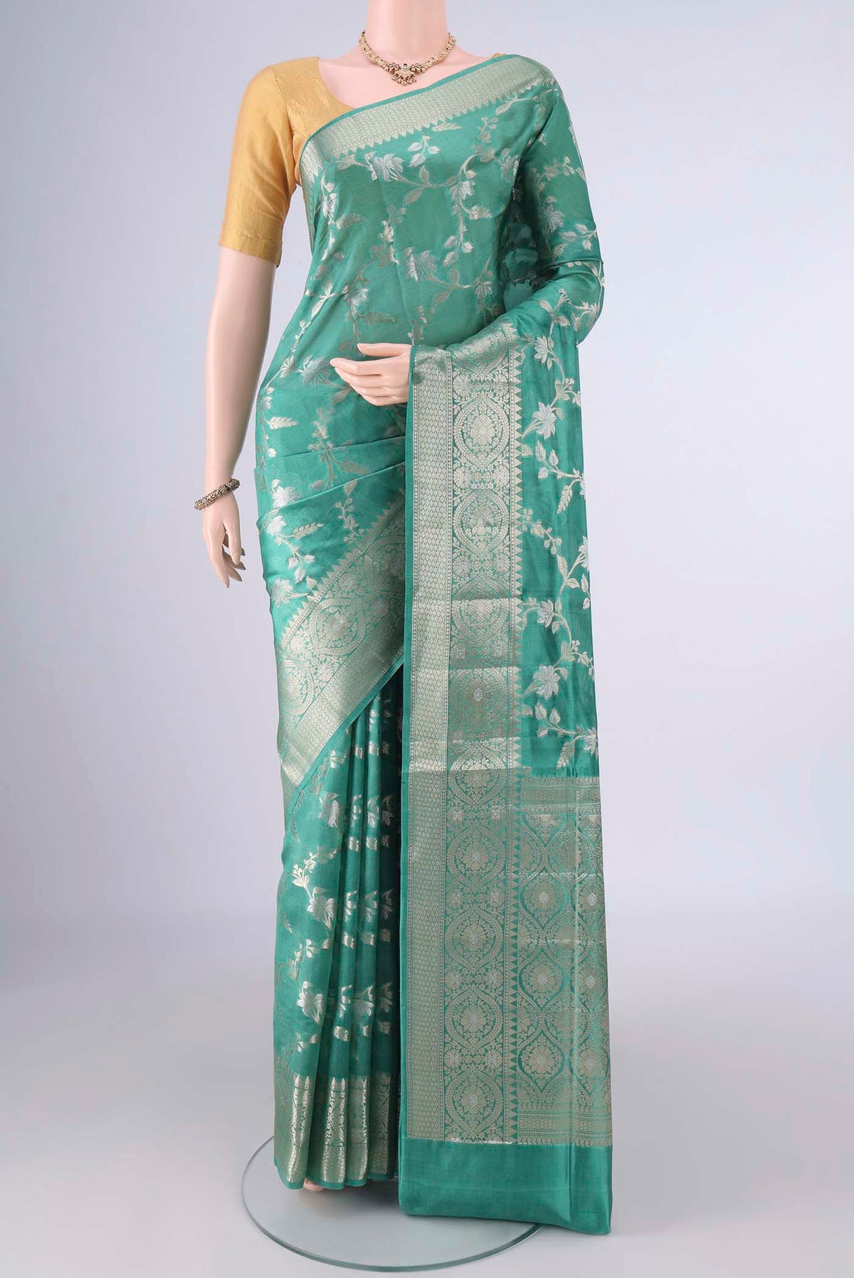 Pure Silk Sea Green Banarasi Raw Saree with Zari Brocade on the body and Zari Border.  displayed on a mannequin