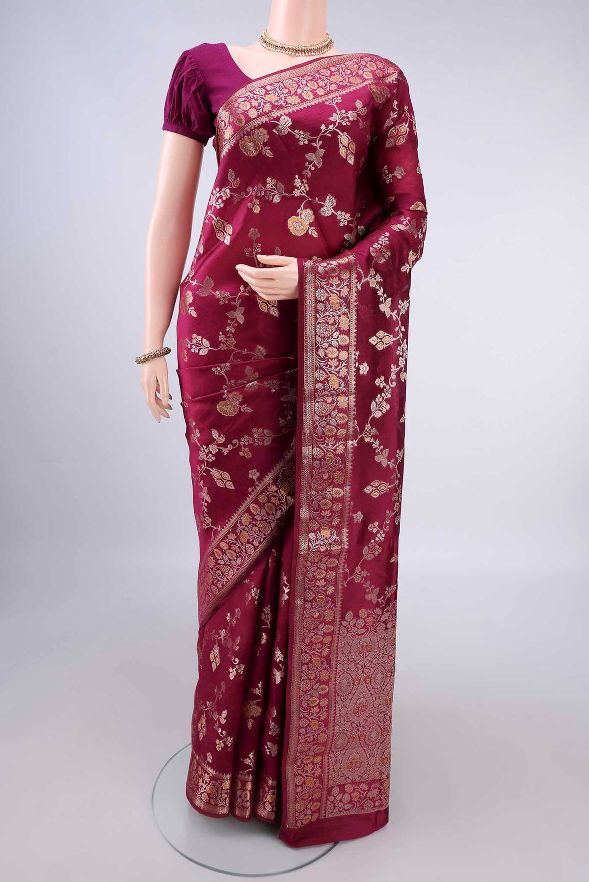 Pure Silk Maroon Banarasi Raw Saree with Zari And Thread Butta on the body and Zari Border.  displayed on a mannequin