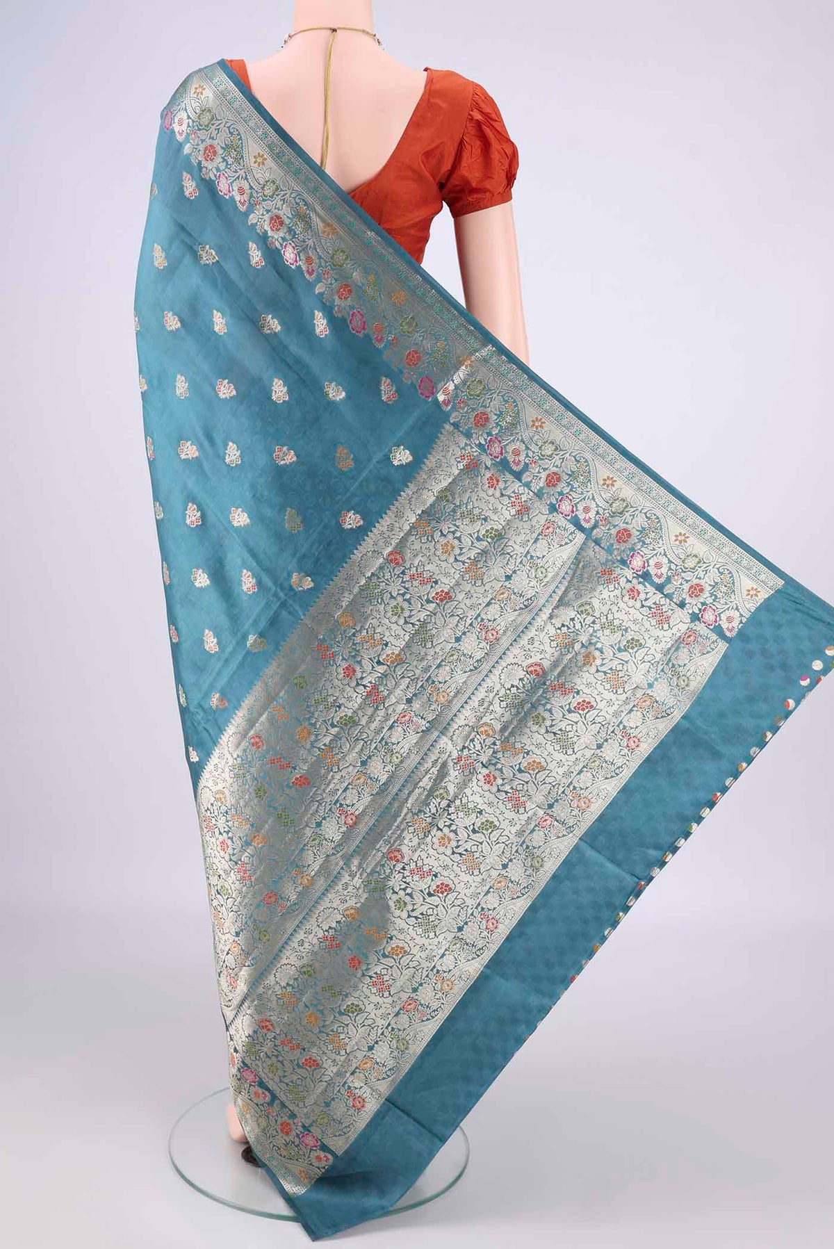 Flat view of Pure Silk Maya Blue Banarasi Raw Saree with Zari Butta on the body and Zari Border. 