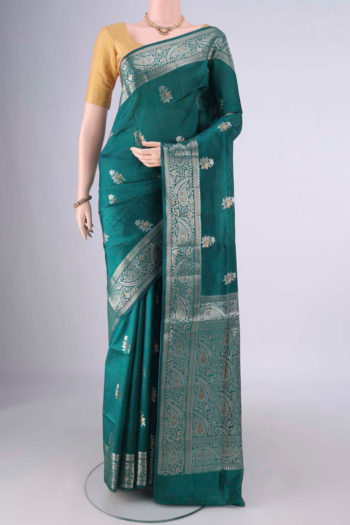 Pure Silk Sea Green Banarasi Raw Saree with Zari And Thread Butta on the body and Zari And Thread Border.  displayed on a mannequin