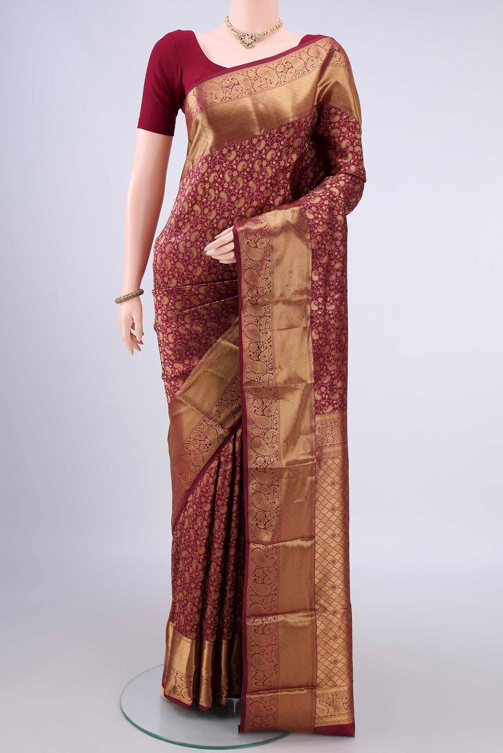 Pure Silk Maroon Kanjivaram Saree with Zari Brocade on the body and Zari Border.  displayed on a mannequin