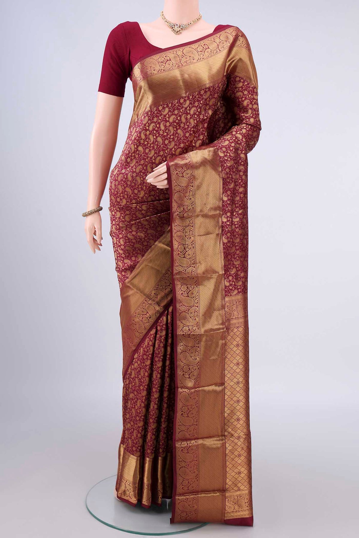 Pure Silk Maroon Kanjivaram Saree with Zari Brocade on the body and Zari Border.  displayed on a mannequin