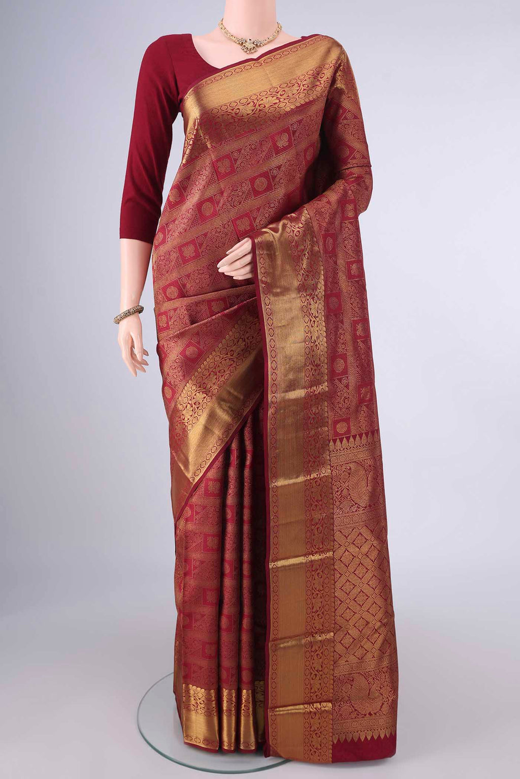 Pure Silk Maroon Kanchipuram Saree with Zari Brocade on the body and Zari Border.  displayed on a mannequin