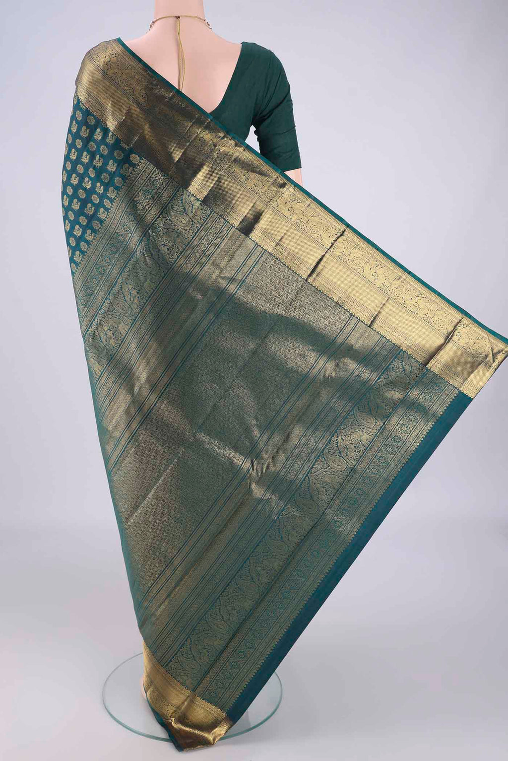 Flat view of Bottle Green Kanchipuram Silk Saree with Zari Butta on the body and Zari Border. 