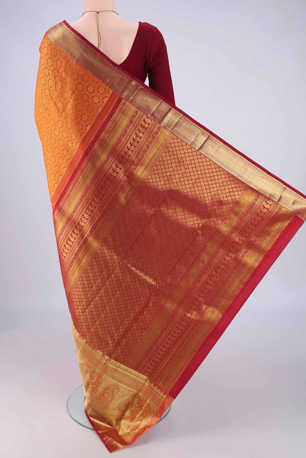 Flat view of Brick Orange Kanjivaram Silk Saree with Zari Brocade on the body and Zari Border. 