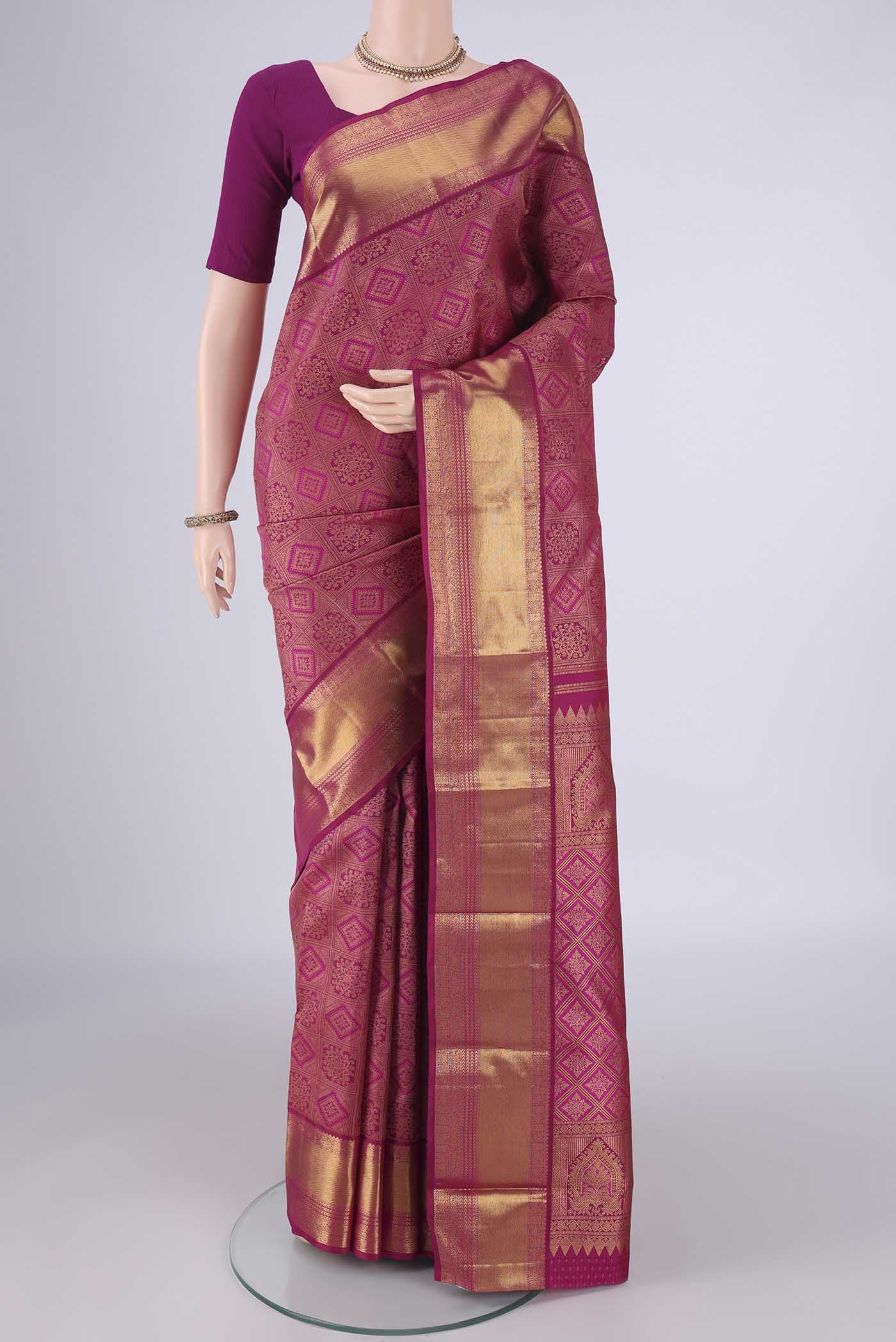 Magenta Kanjivaram Silk Saree with Zari Brocade on the body and Zari Border.  displayed on a mannequin